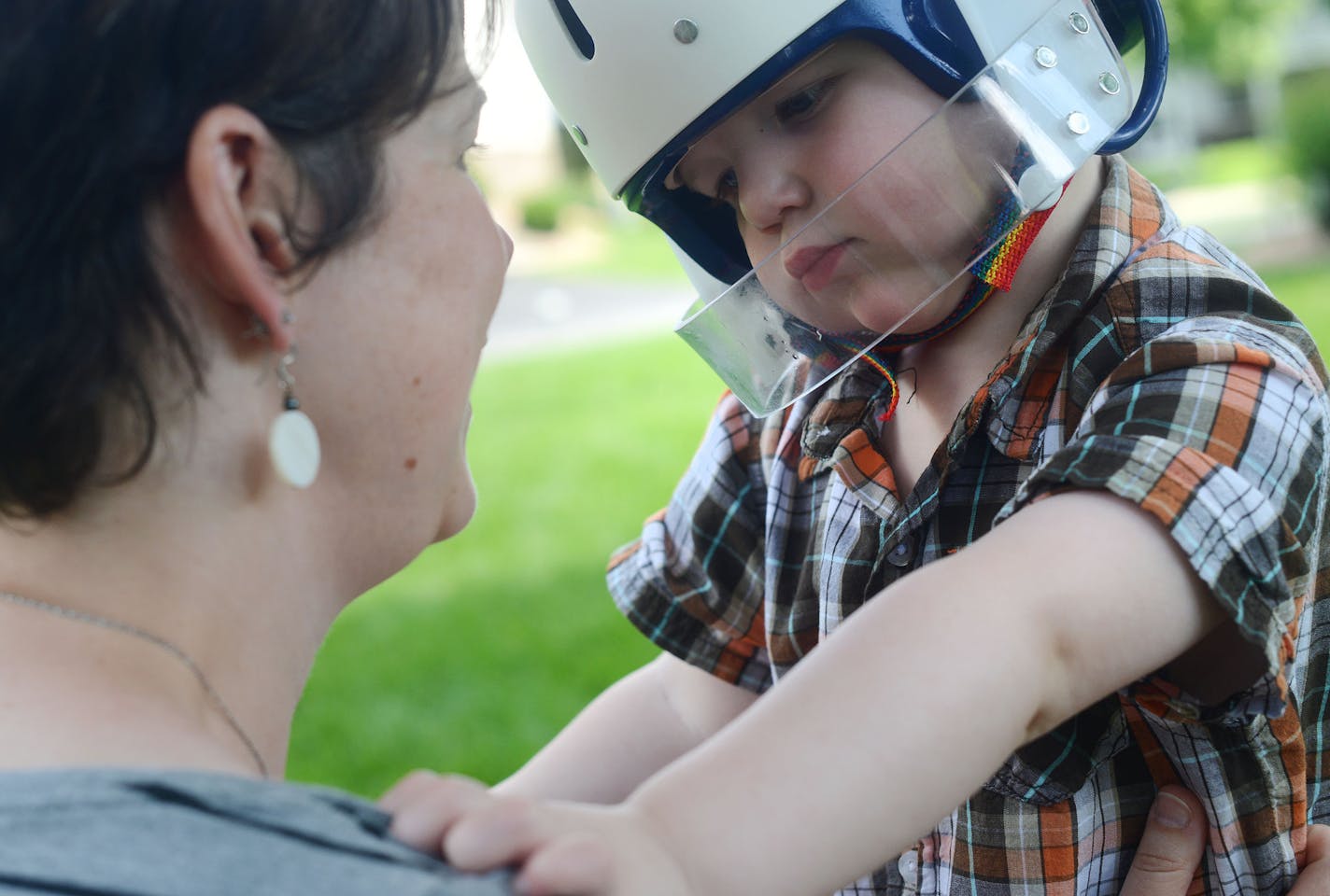 Wyatt Hauser, 3, helmeted against head injuries, relaxed during a seizure-free moment with his mom, Jessica Hauser.