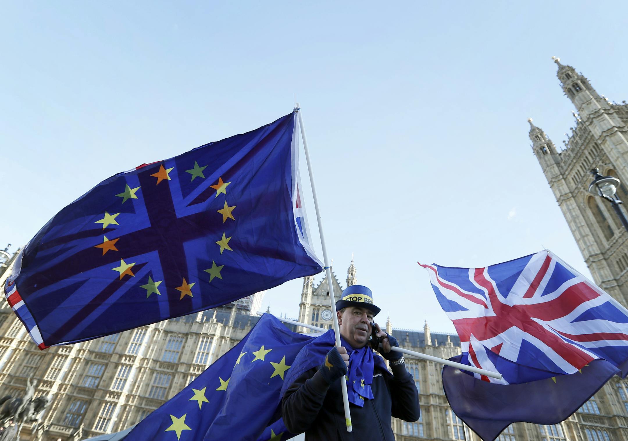 An anti Brexit demonstrator waves EU and British flags in Westminster in London, Friday, Dec. 8, 2017. British Prime Minister Theresa May, met with European Commission President Jean-Claude Juncker early Friday morning following crucial overnight talks on the issue of the Irish border. (AP Photo/Kirsty Wigglesworth)