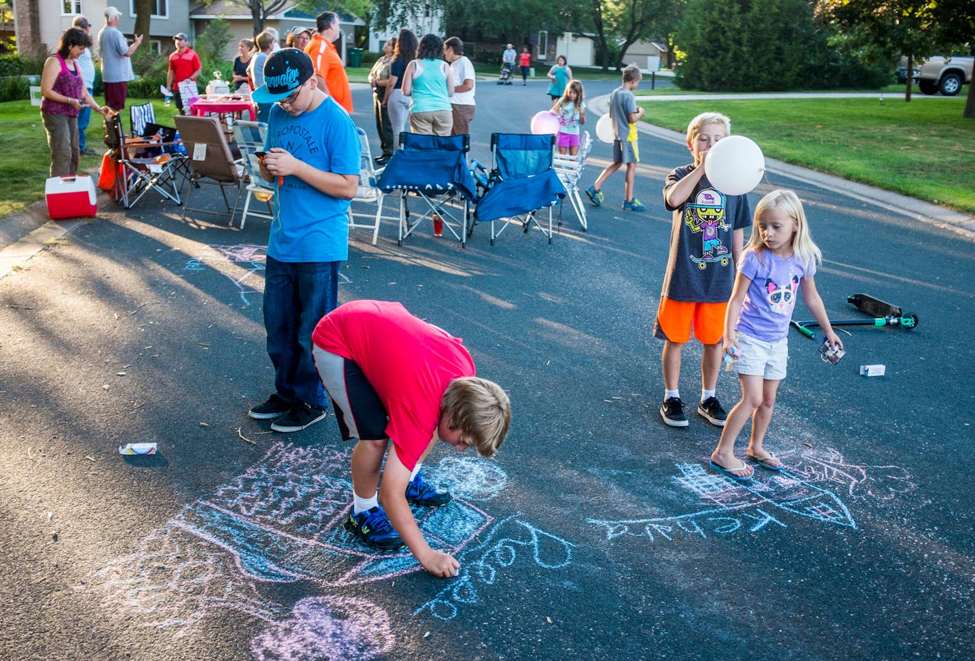 12-year-old Joey Osland, 12-year-old Reese Reitzel, 10-year-old Luke Reitzel and six-year-old Kendra Reitzel finished chalk drawings of their houses to win prizes at the Hanson-Ridgeview block party. ] Mark Vancleave - mark.vancleave@startribune.com * Vadnais Heights residents gather for a National Night Out block party with kids activities and a pot luck Tuesday, Aug. 4, 2015.