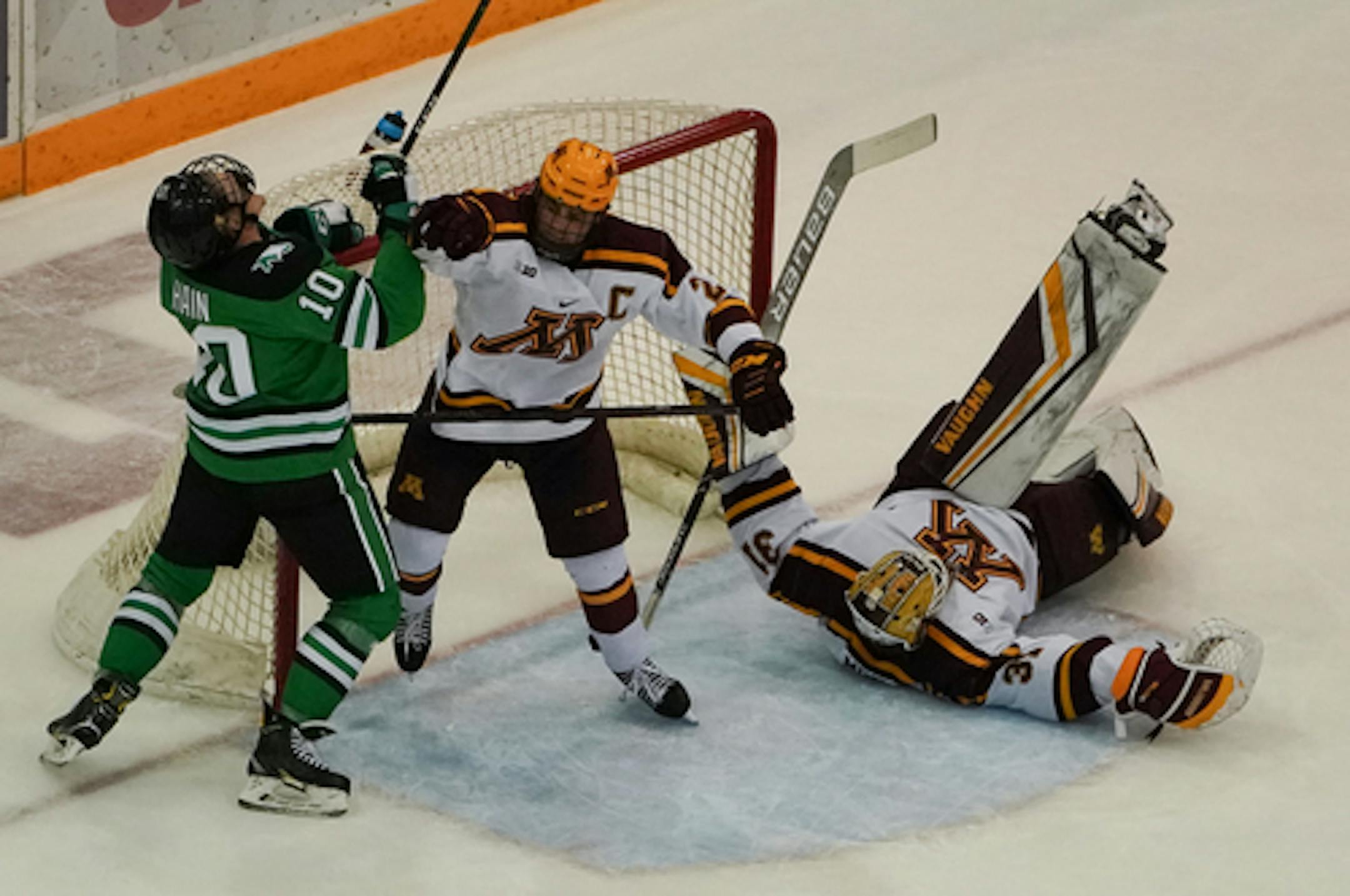 Gophers defenseman Tyler Nanne, center, battled North Dakota's Gavin Hain as Minnesota goalie Jared Moe hit the ice during North Dakota's 9-3 win on Thanksgiving night.