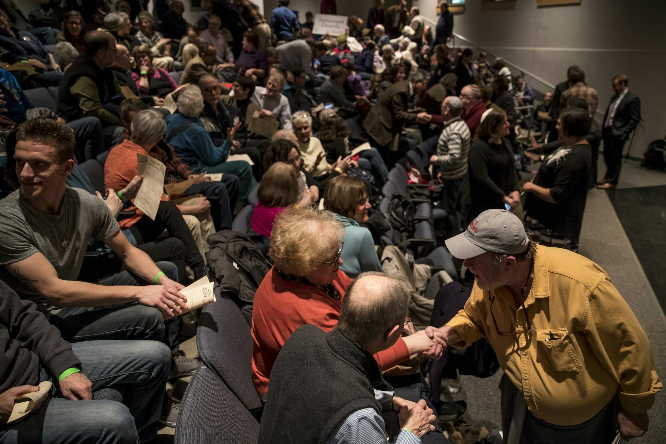 A packed crowd took a minute to greet each other during an interfaith rally at the Highland Park Community Center on Thursday, March 2, 2017, in St. Paul, Minn.