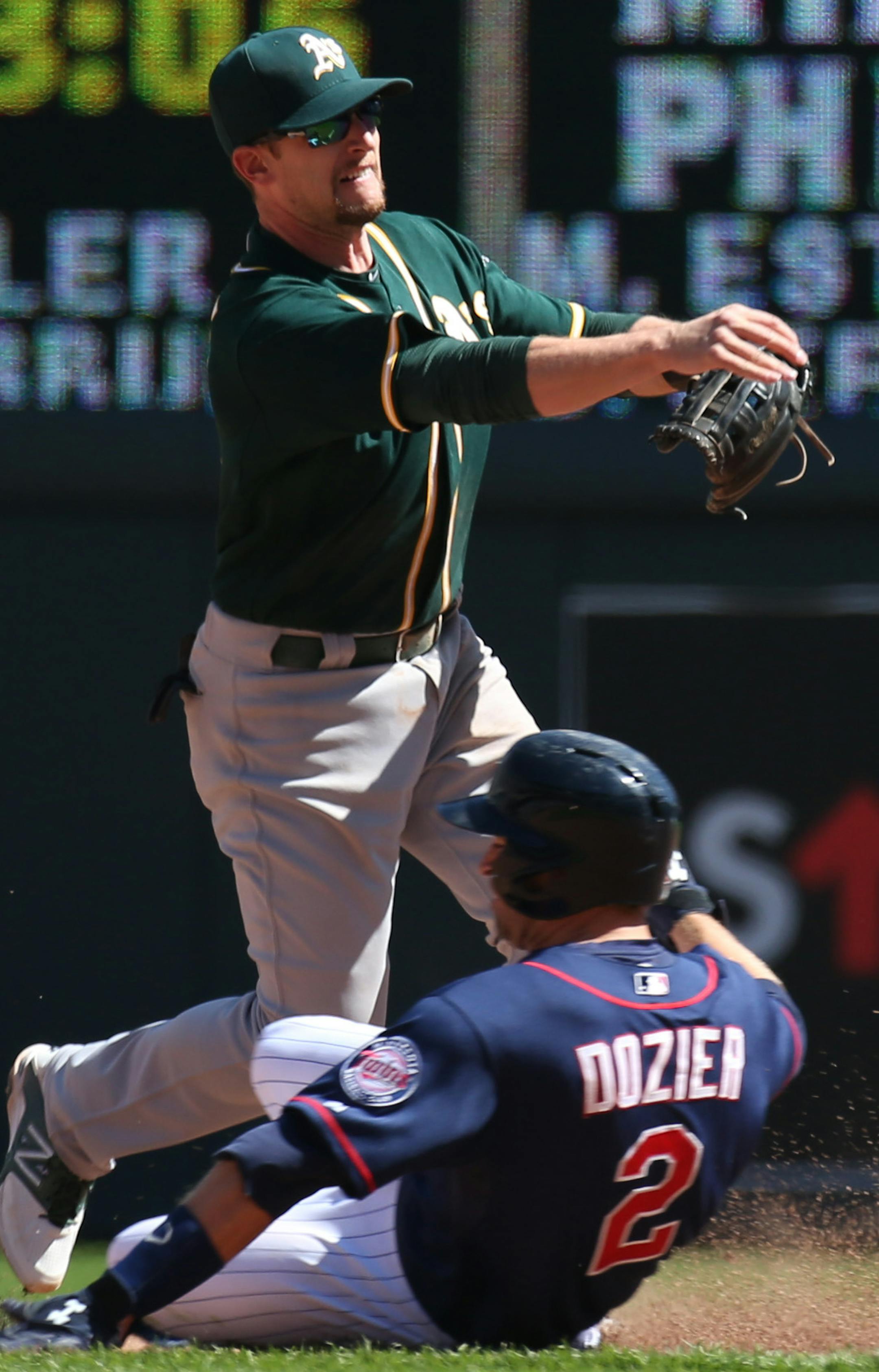(left to right) A's Jed Lowrie made the throw to first for the double play as Twins Brian Dozier was out at 2nd base.] Minnesota Twins vs. Oakland A's, 4/10/14.] Bruce Bisping/Star Tribune bbisping@startribune.com Jed Lowrie, Brian Dozier/roster.