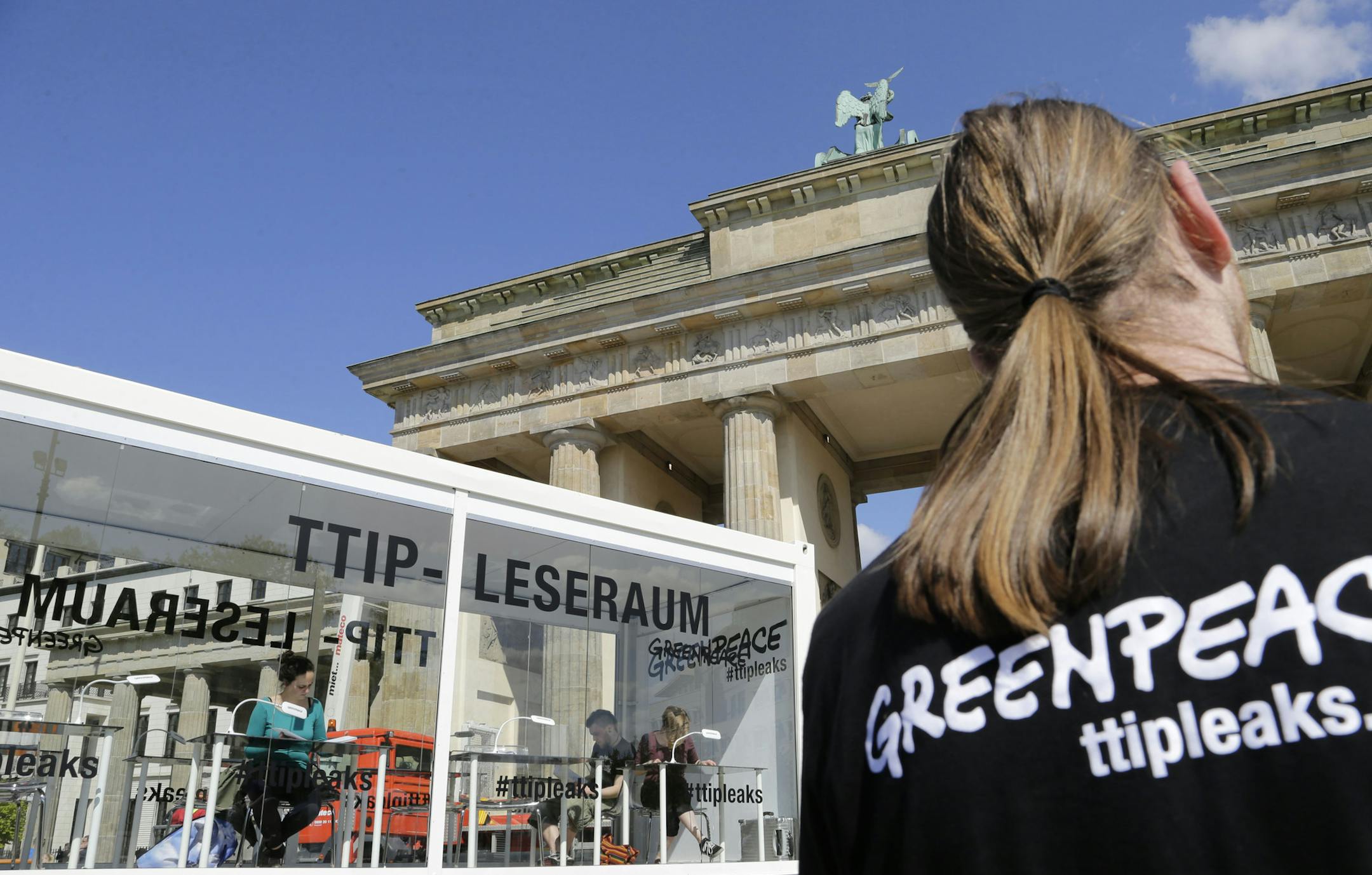 People read documents on the Trans-Atlantic talks to create a massive free trade zone between the United States and the European Union in a 'TTIP reading room' set up by Greenpeace in front of the Brandenburg Gate in Berlin, Germany, Monday, May 2, 2016. Greenpeace released confidential negotiating texts that the environmental group claims shows U.S. ill intent. (AP Photo/Ferdinand Ostrop)