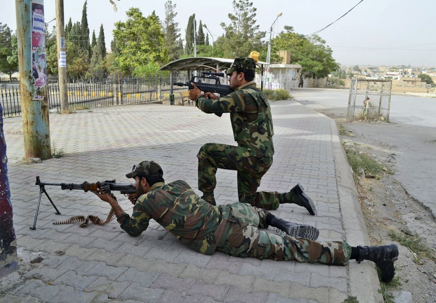 Pakistani security forces take up positions outside a hospital during a gun battle in Quetta, Pakistan, Saturday, June 15, 2013. Gunmen took over parts of a hospital in southwestern Pakistan Saturday after a bomb went off inside its emergency room, officials said. Several people died before authorities stormed the building and freed the hostages trapped inside.