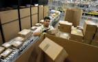 Ricardo Sandoval places packages in the right shipping boxes at an Amazon.com fulfillment center, in Phoenix.