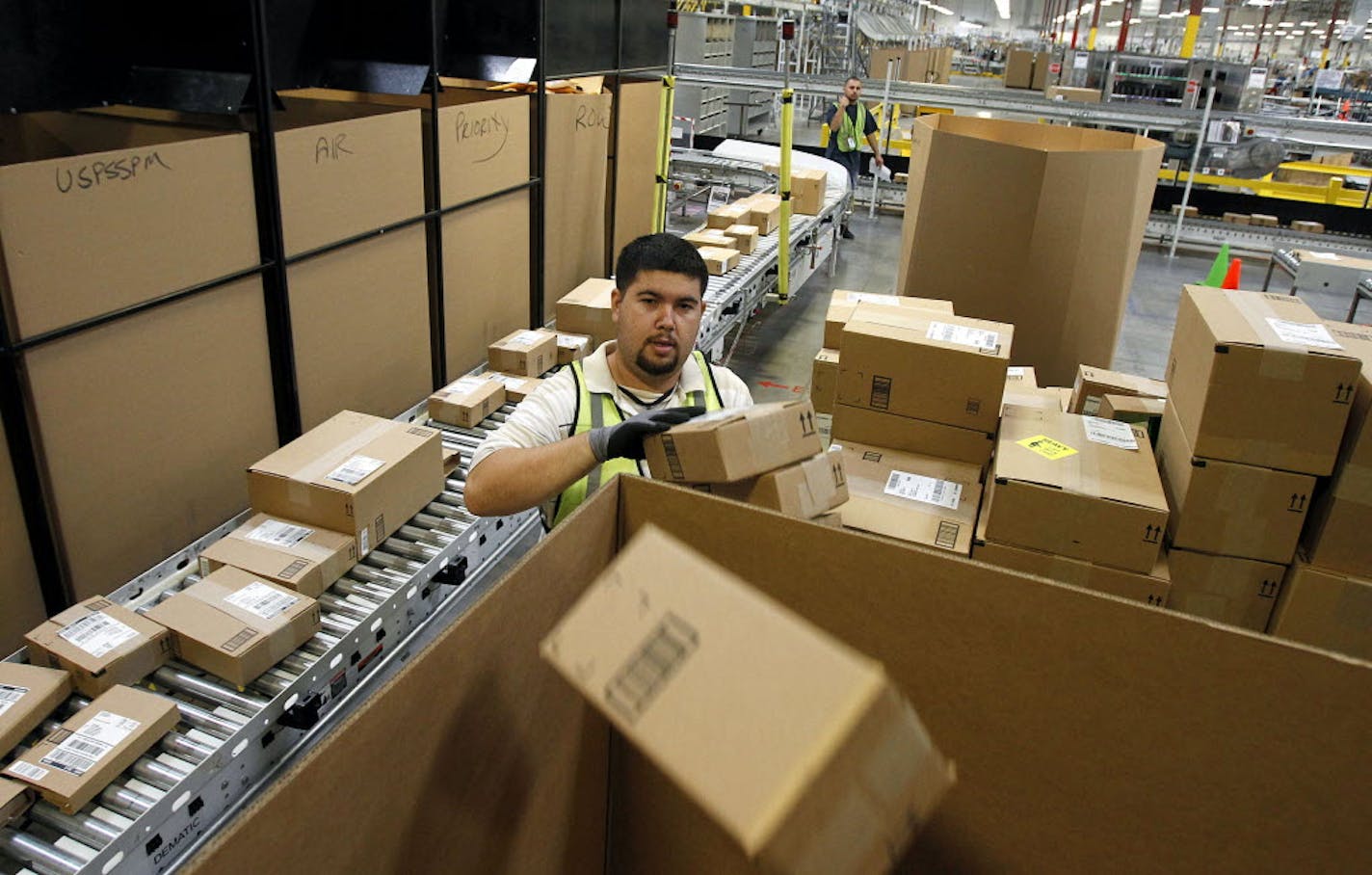 Ricardo Sandoval places packages in the right shipping boxes at an Amazon.com fulfillment center, in Phoenix.