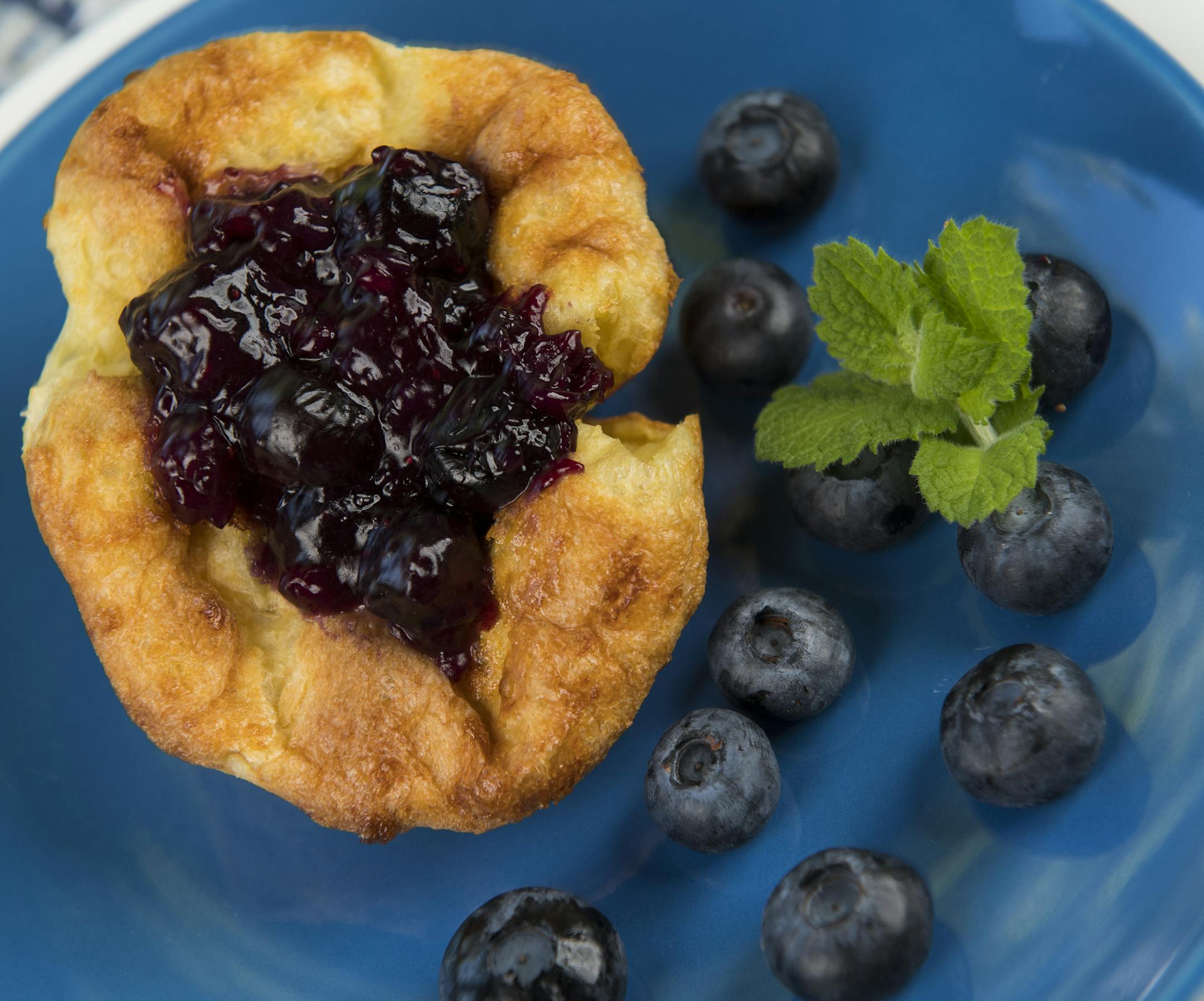 Finished Dutch Puff with blueberry compote, blueberries, and basil. ] Isaac Hale ï isaac.hale@startribune.com Baking Central: Making Dutch Puffs in muffin tin and blueberry compote on Wednesday, July 13, 2016.