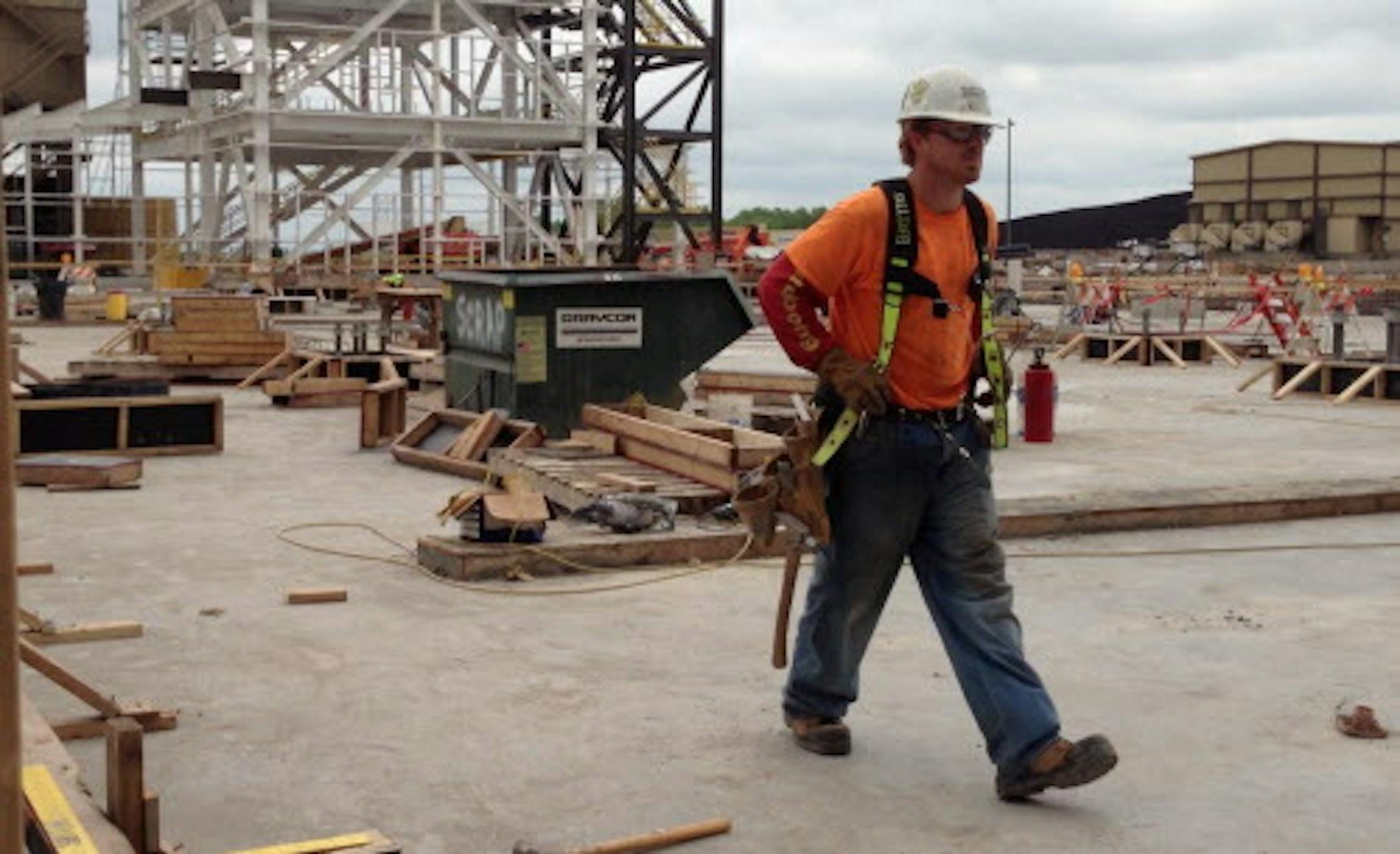 A construction worker walks across the hardened concrete foundation poured recently for a $405 million air pollution control upgrade at the coal-fired Big Stone power plant in South Dakota just across the border from Ortonville, Minn. The plant, owned by Otter Tail Power Co. of Fergus Falls, Minn., and two South Dakota utilities, is one of many coal-burning power plants across the United States that require expensive retrofits to reduce mercury and other emissions. But the new smokestack control