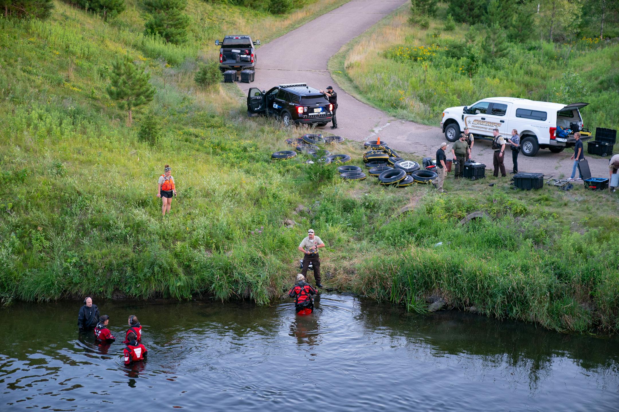 Water Recovery authorities comb the Apple River with metal detectors after five people were stabbed while tubing down the river Saturday, July 30, 2022 in Somerset, WI.   ]