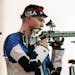 Patrick Sunderman, right, of the United States, competes in the men's 50-meter 3 positions rifle at the Asaka Shooting Range in the 2020 Summer Olympi