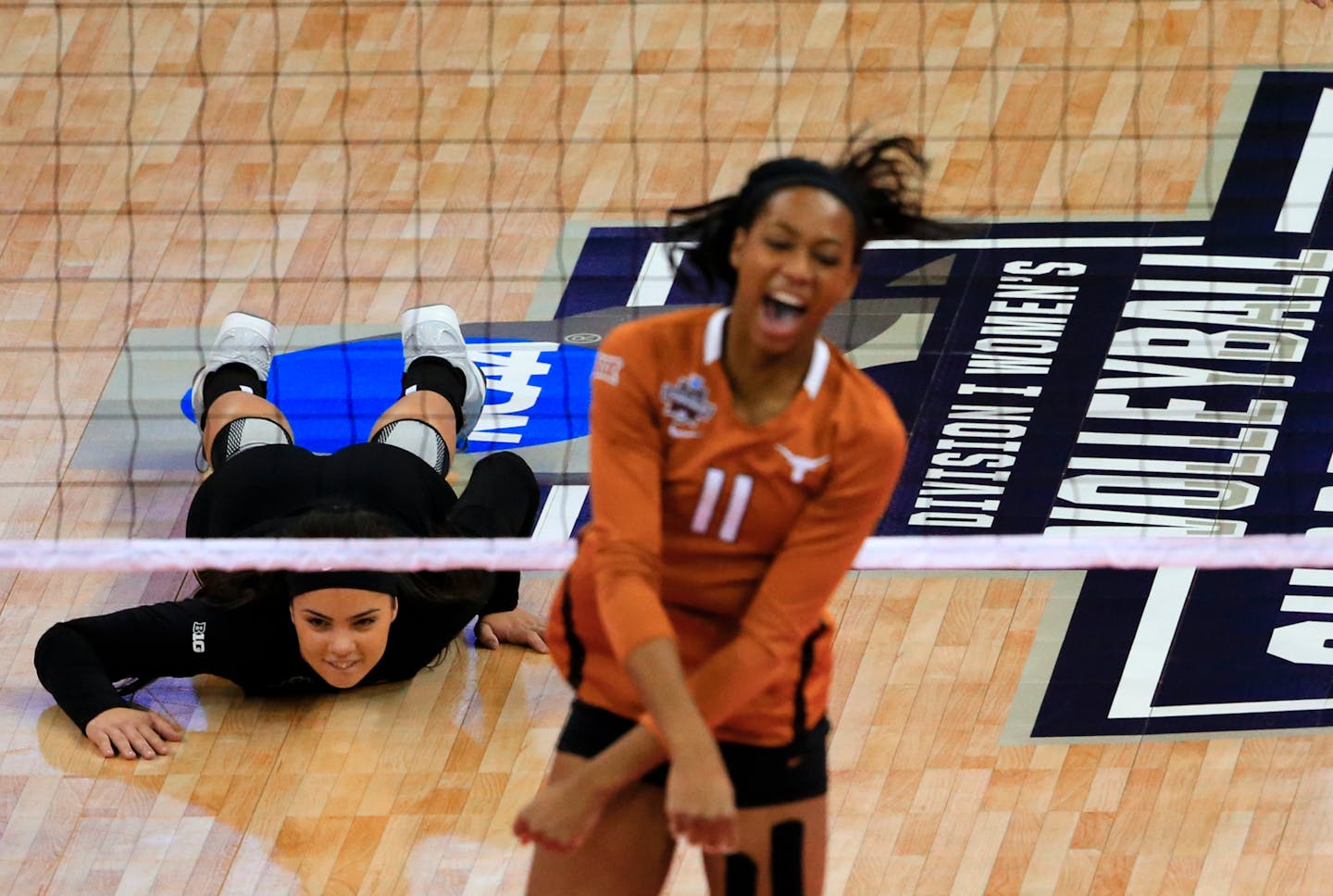 Minnesota's Dalianliz Rosado lies on the court as Texas' Chiaka Ogbogu (11) celebrates a kill during an NCAA women's volleyball tournament semifinal in Omaha, Neb., Thursday, Dec. 17, 2015. (AP Photo/Nati Harnik)