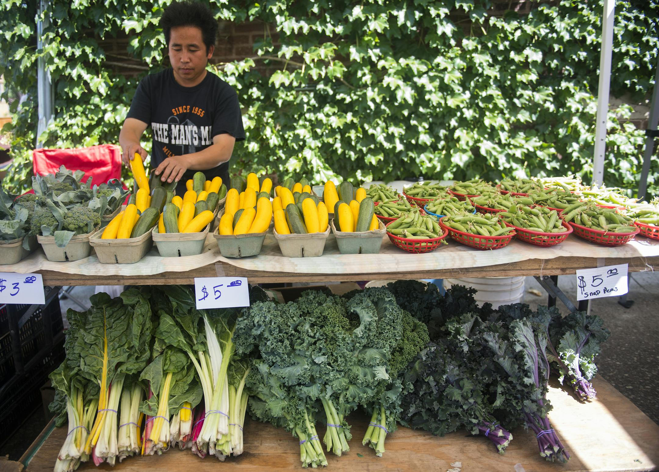 Naton Vang organized his produce at the Whittier Farmers Market held behind Calvary Baptist Church.