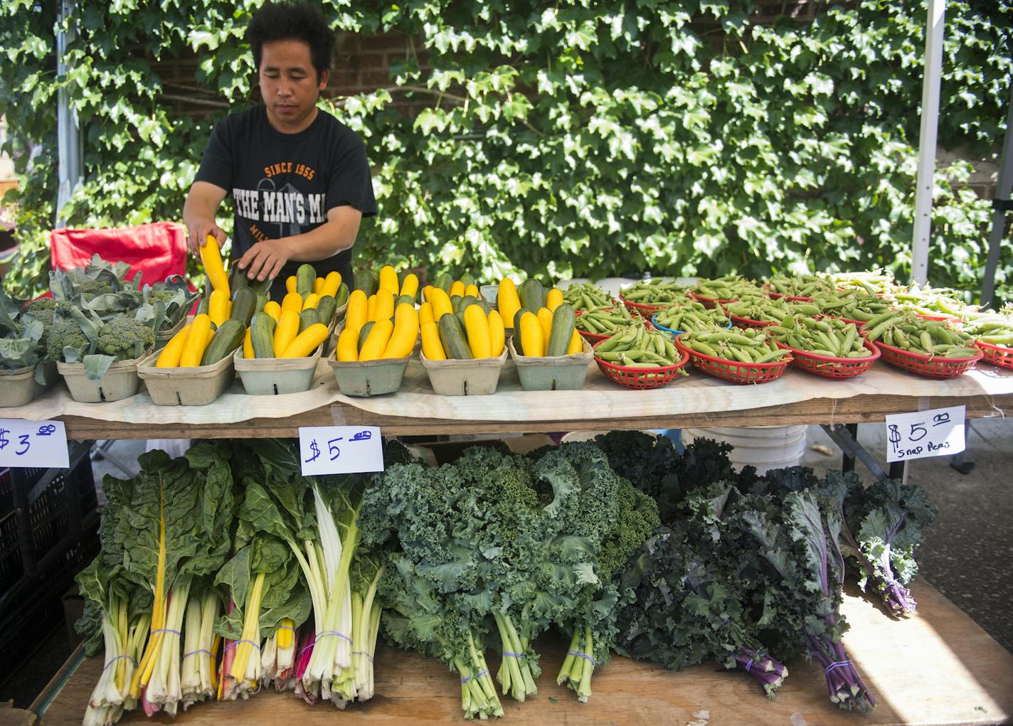 Naton Vang organized his produce at the Whittier Farmers Market held behind Calvary Baptist Church.