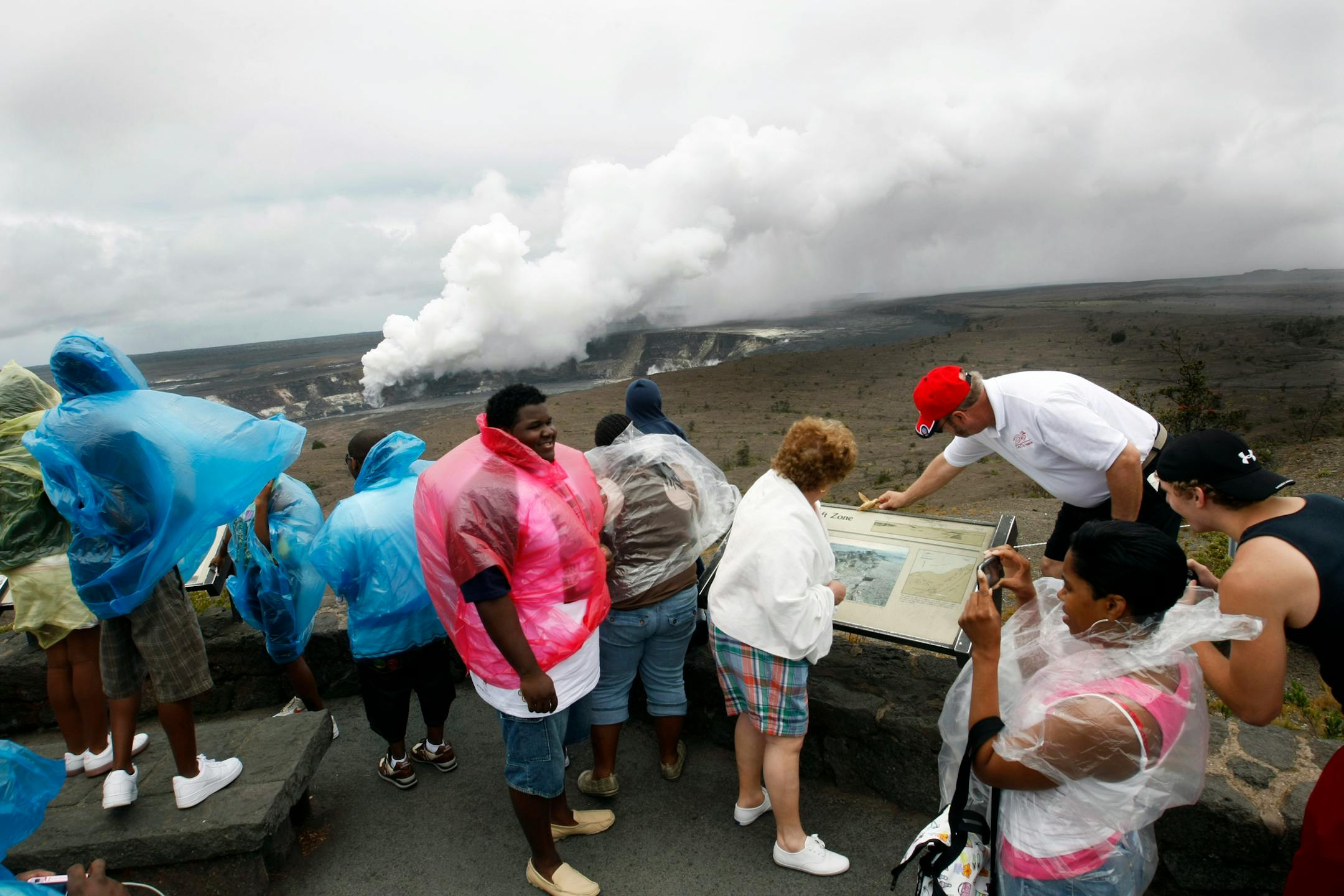 Visitors stop at the lookout of the Jaggar Museum to catch a glimpse of the gas plume from the Halema'uma'u vent. Dangerous levels of sulfur dioxide has caused part of the loop drive around the Kilauea Caldera to be closed to the public.