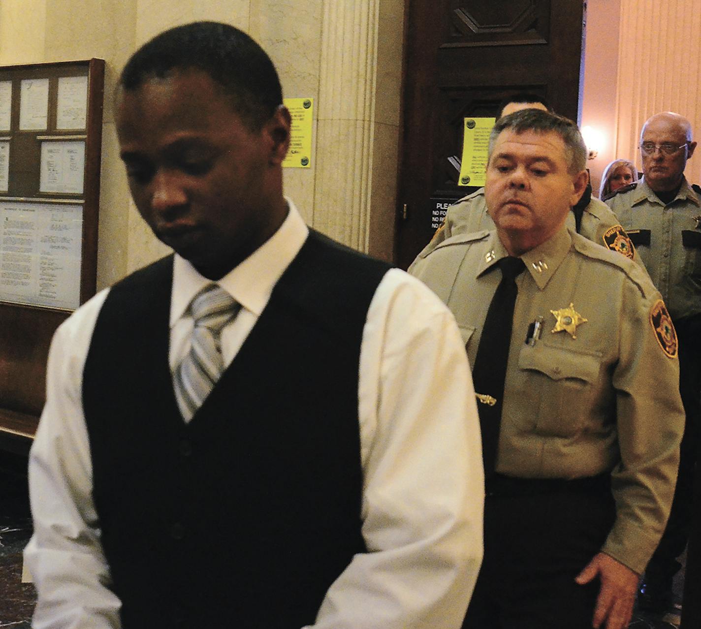 Flint McColgan/MDN In this Feb. 4, 2013, file photo, Omar Mohamed Kalmio, left, is being led from court by Captain Michael Nason of the Ward County Sheriff&#x201a;&#xc4;&#xf4;s Department, among other deputies, after the jury reached their verdict. He was convicted of the Jan. 28, 2011, murders of his girlfriend and three others.