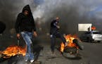 Palestinians burn tires during clashes with Israeli troops following a protest against U.S. President Donald Trump's decision to recognize Jerusalem a