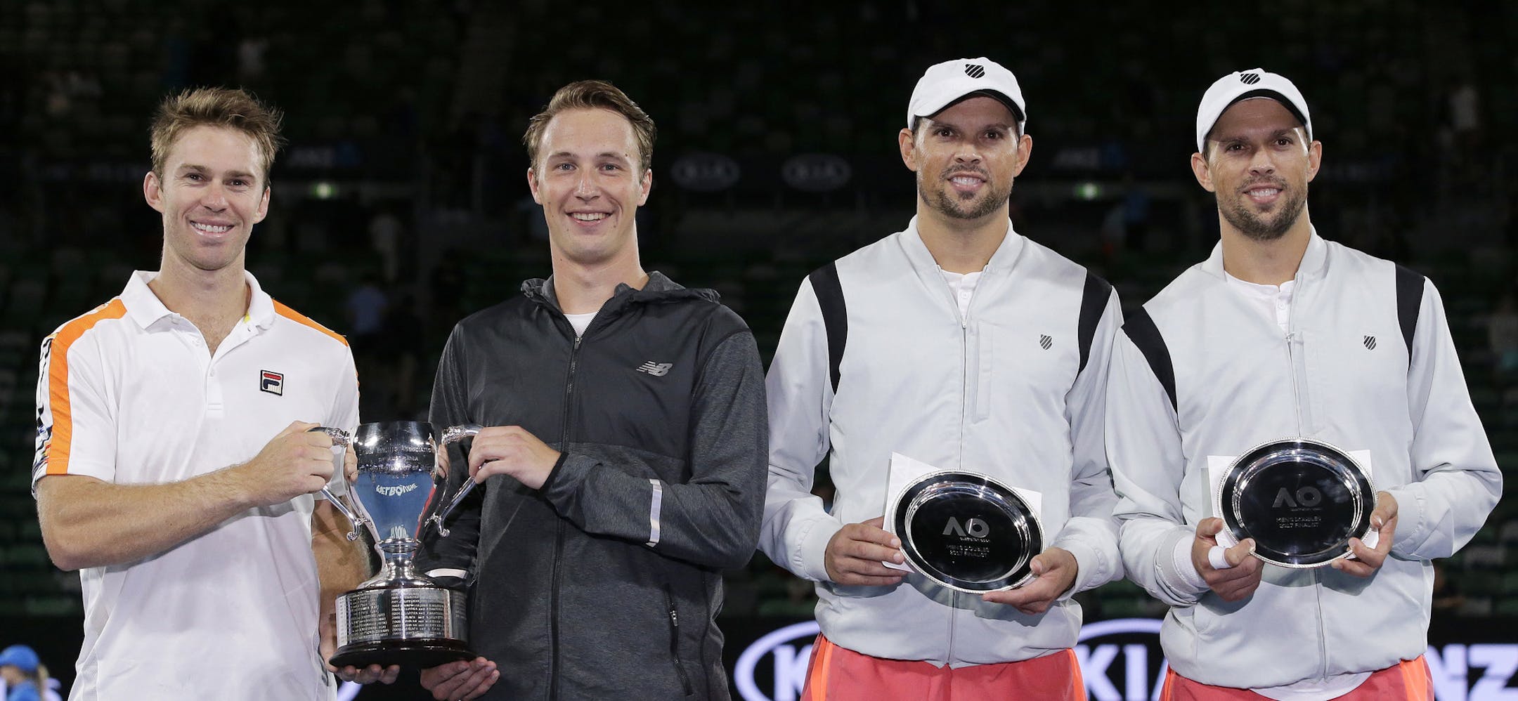 Australia's John Peers, left, and Finland's Henri Kontinen, second left, hold the winners trophy after defeating Bob and Mike Bryan of the US in the men's doubles final at the Australian Open tennis championships in Melbourne, Australia, Saturday, Jan. 28, 2017. (AP Photo/Aaron Favila)