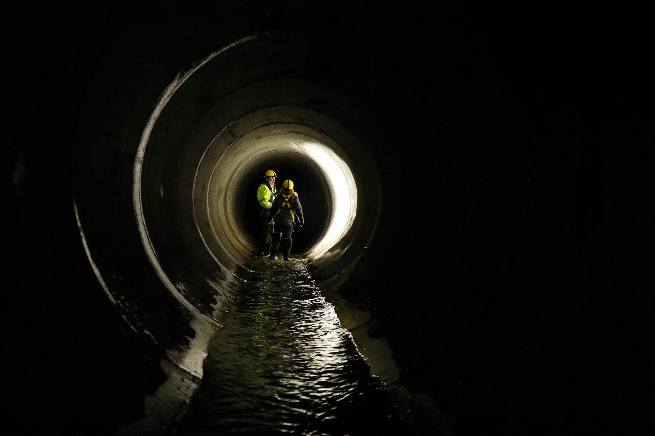 City of Minneapolis employees talked during a tour of an underground tunnel.