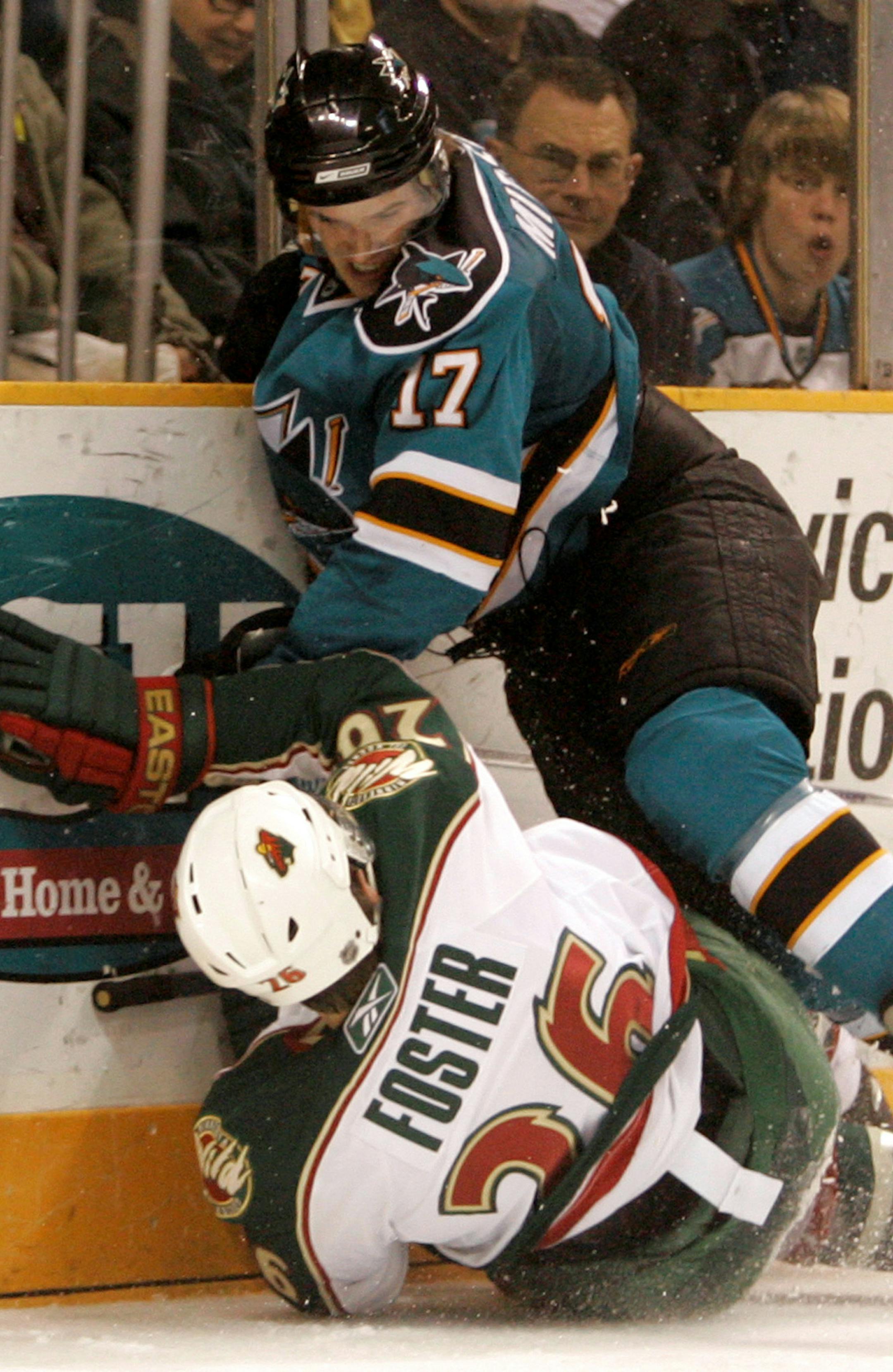 Minnesota Wild defenseman Kurtis Foster, bottom, collides with San Jose Sharks center Torrey Mitchell, top, in the second period of an NHL hockey game in San Jose, Calif., Wednesday, March 19, 2008. Foster left the game with an injury after the play. (AP Photo/Marcio Jose Sanchez)
