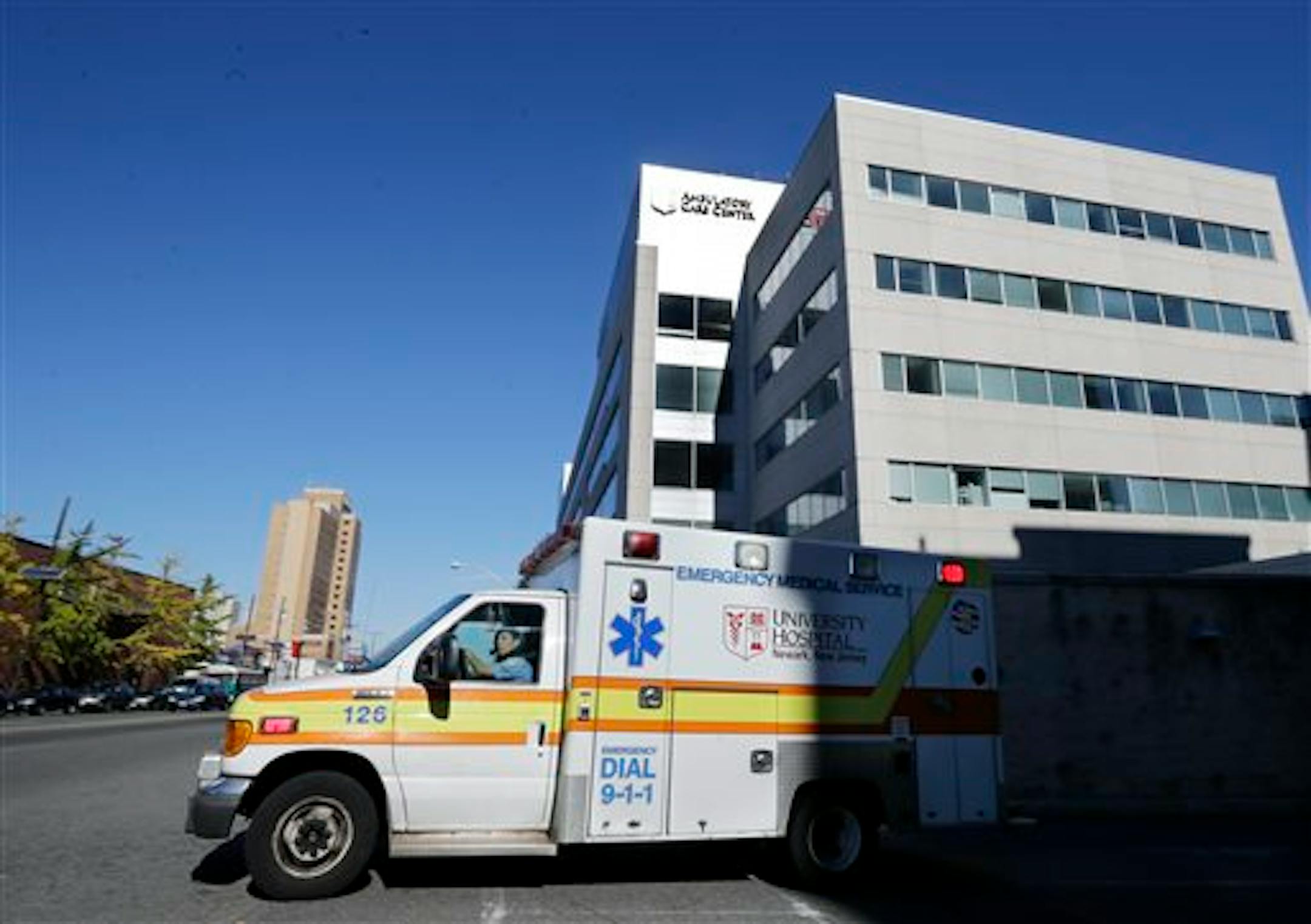 FILE- In this Oct. 27, 2014, file photo, an ambulance drives near University Hospital of Newark in Newark, N.J. Nurse Kaci Hickox, who was quarantined at the hospital after working in West Africa with Ebola patients, was released Monday and left the hospital in a private vehicle. Even small clusters of Ebola cases could overwhelm parts of US medical care system, according to an Associated Press review of readiness at hospitals and other components of the emergency medical network. (AP Photo/Mel
