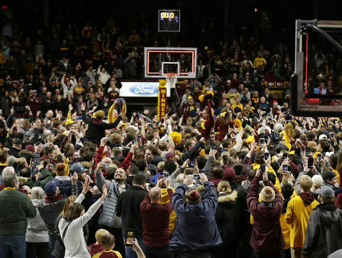 Minnesota fans storm the court after an upset victory over Ohio State in an NCAA college basketball game Sunday, Dec. 15, 2019, in Minneapolis. (AP Photo/Andy Clayton-King)