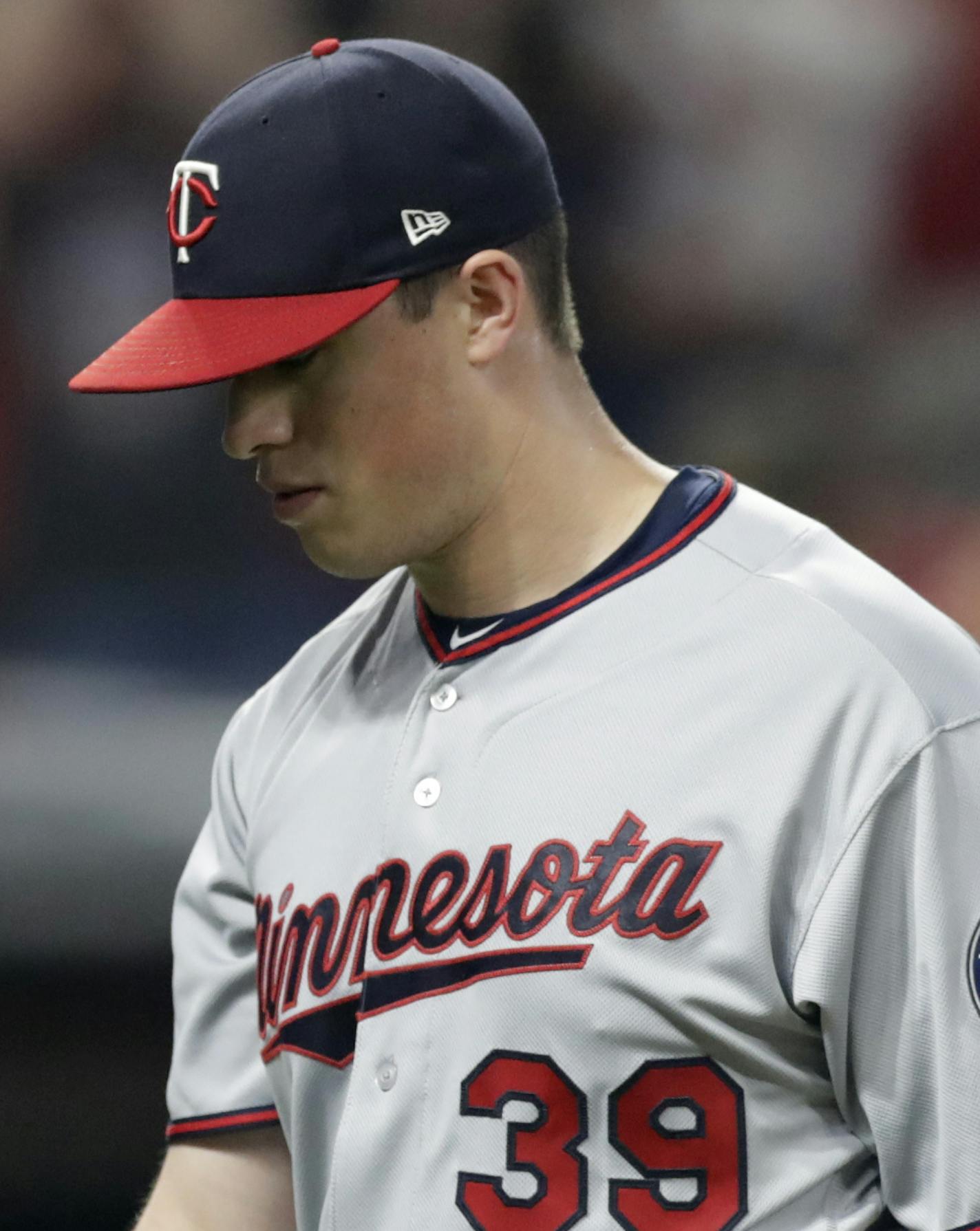 Minnesota Twins relief pitcher Trevor Hildenberger walks off the field after giving up a walk-off three-run home run in the team's baseball game against the Cleveland Indians, Wednesday, Aug. 8, 2018, in Cleveland. The Indians won 5-2. (AP Photo/Tony Dejak)