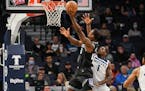 Sacramento Kings forward Harrison Barnes, left, drives past Minnesota Timberwolves guard Anthony Edwards to score during the first half of an NBA bask