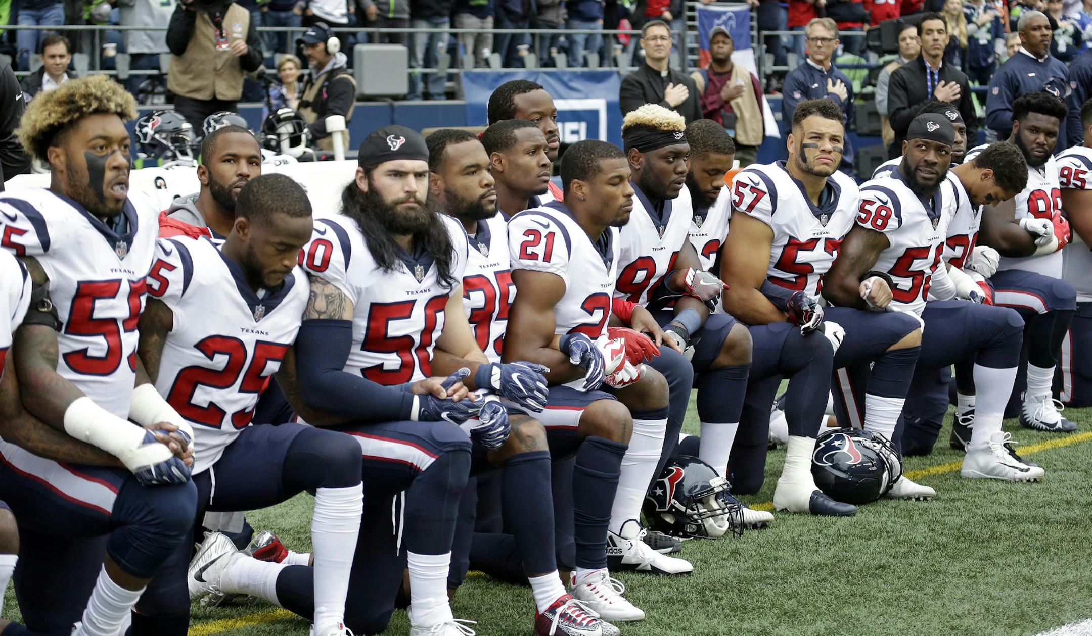 Houston Texans players kneel during the singing of the national anthem before an NFL football game against the Seattle Seahawks, Sunday, Oct. 29, 2017, in Seattle. (AP Photo/Elaine Thompson)