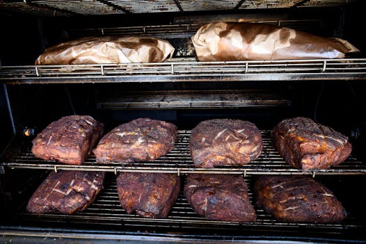 Pork butts and briskets being smoked at OMC Smokehouse