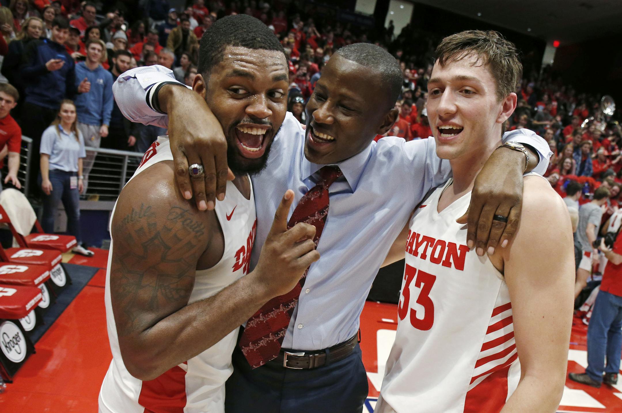 Dayton coach Anthony Grant, center, gives a hug to players Trey Landers, left, and Ryan Mikesell following the team's 82-67 win over Davidson in an NCAA college basketball game Friday, Feb. 28, 2020, in Dayton, Ohio. (AP Photo/Gary Landers) ORG XMIT: MER5919d22d345a988f666504d824d08