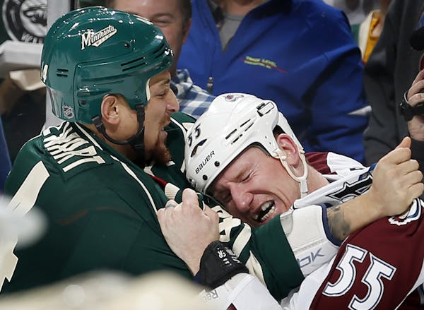 The Wild's Chris Stewart, left, and Colorado's Cody McLeod fought in the first period Sunday.