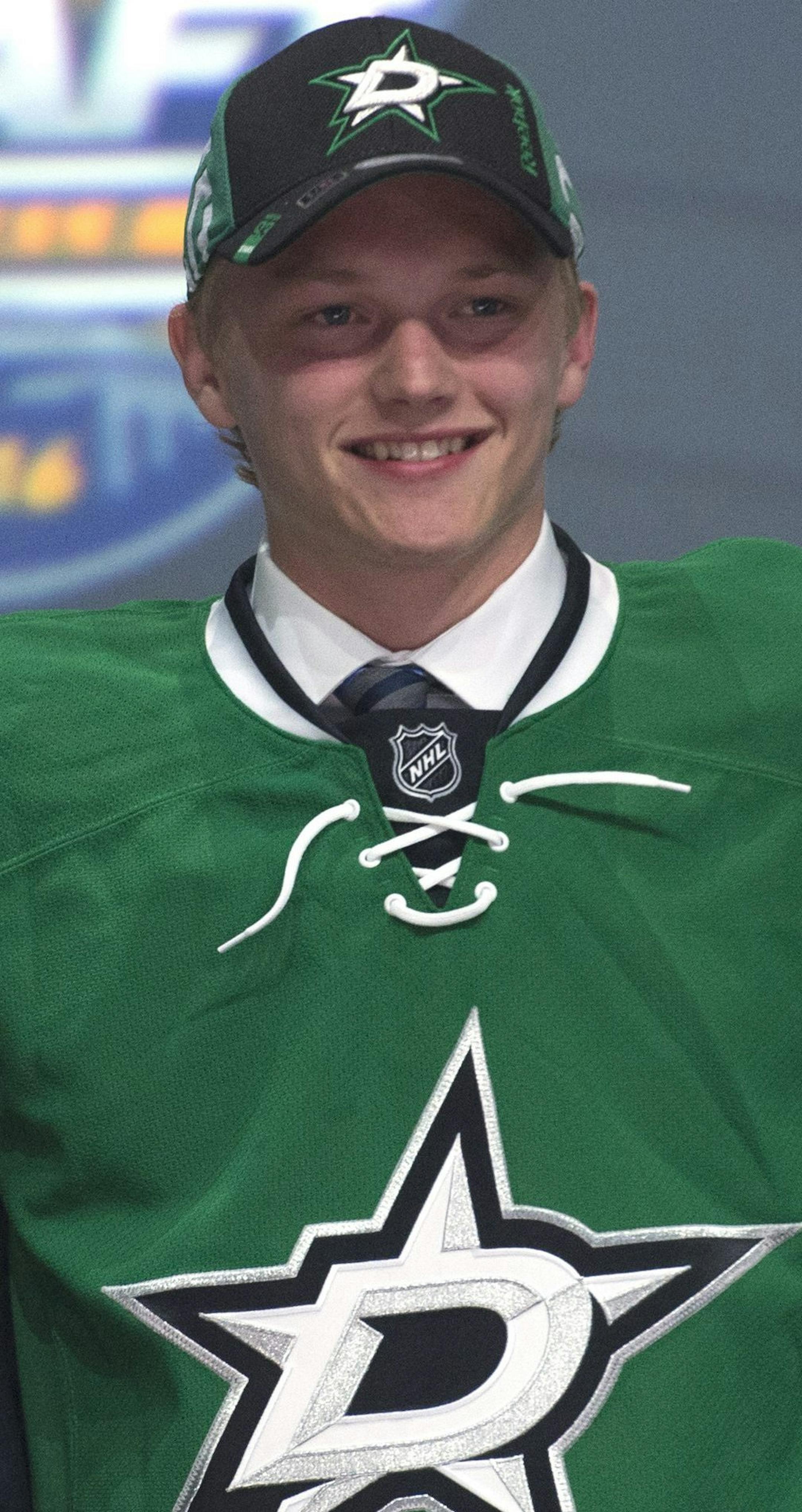 Riley Tufte, center, stands with members of the Dallas Stars management team at the NHL draft in Buffalo, N.Y., Friday June 24, 2016. (Nathan Denette/The Canadian Press via AP) MANDATORY CREDIT