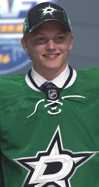 Riley Tufte, center, stands with members of the Dallas Stars management team at the NHL draft in Buffalo, N.Y., Friday June 24, 2016. (Nathan Denette/