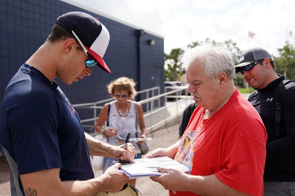 Minnesota Twins right fielder Max Kepler (26) signed autographs for fans after an informal workout at spring training.