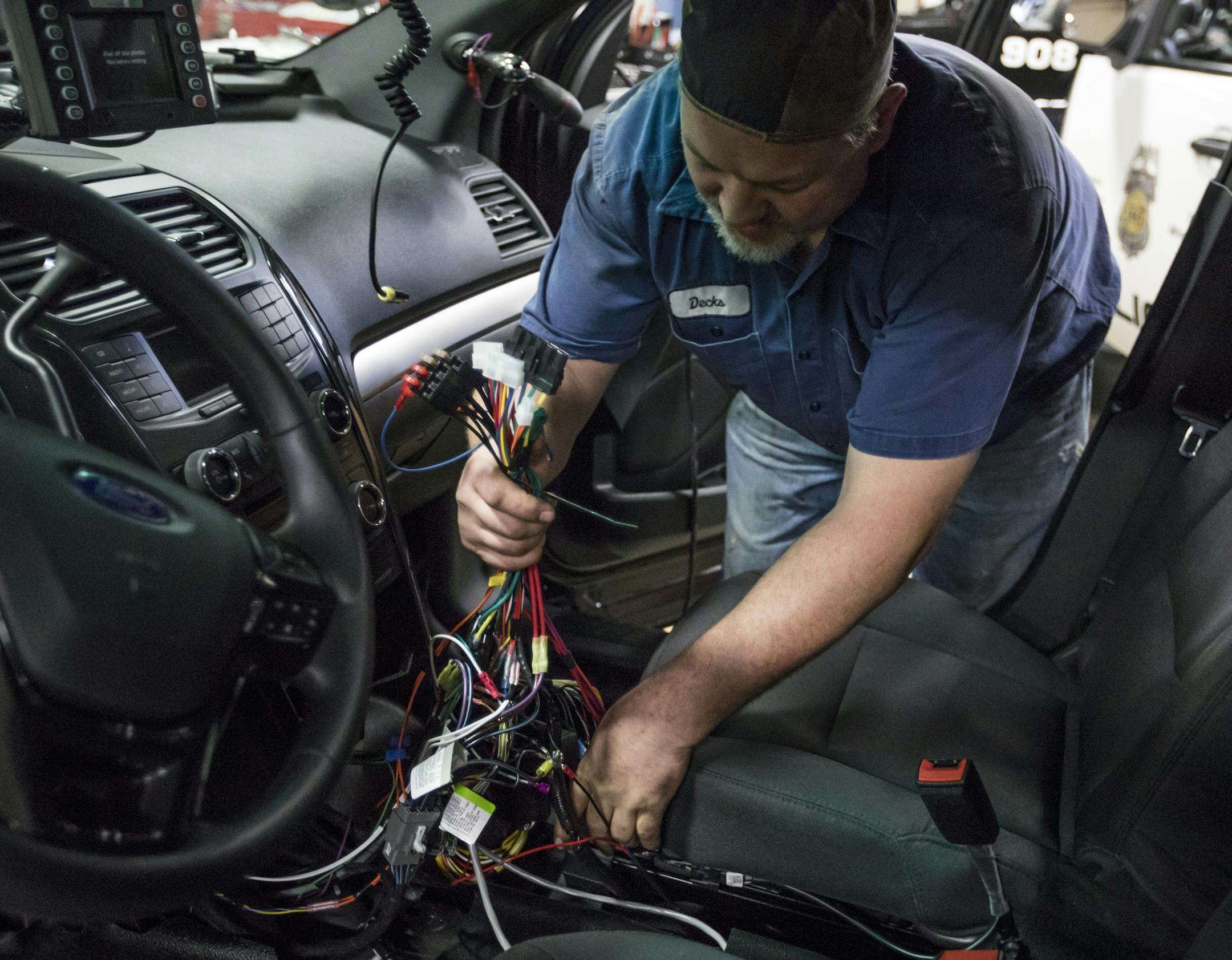 Public works mechanic Christopher Decker showed the wiring that goes into the new police Ford Explorers being built at the Royalston Maintenance Facility on Tuesday, November 29, 2016, in Minneapolis, Minn. At left is the new explorers ] RENEE JONES SCHNEIDER • renee.jones@startribune.com