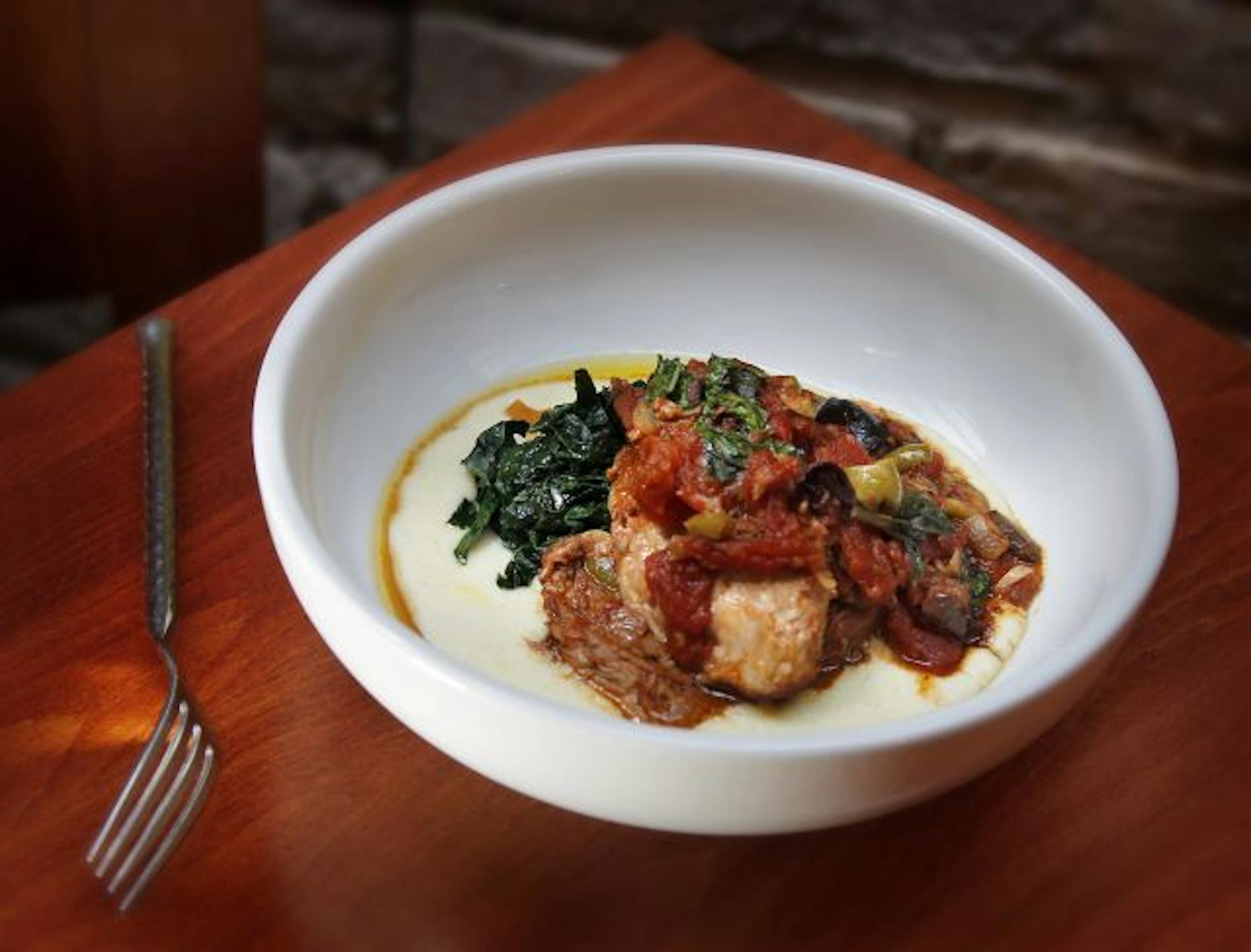 Signature dish: Slow-roasted pork with tomatoes and basil over polenta.