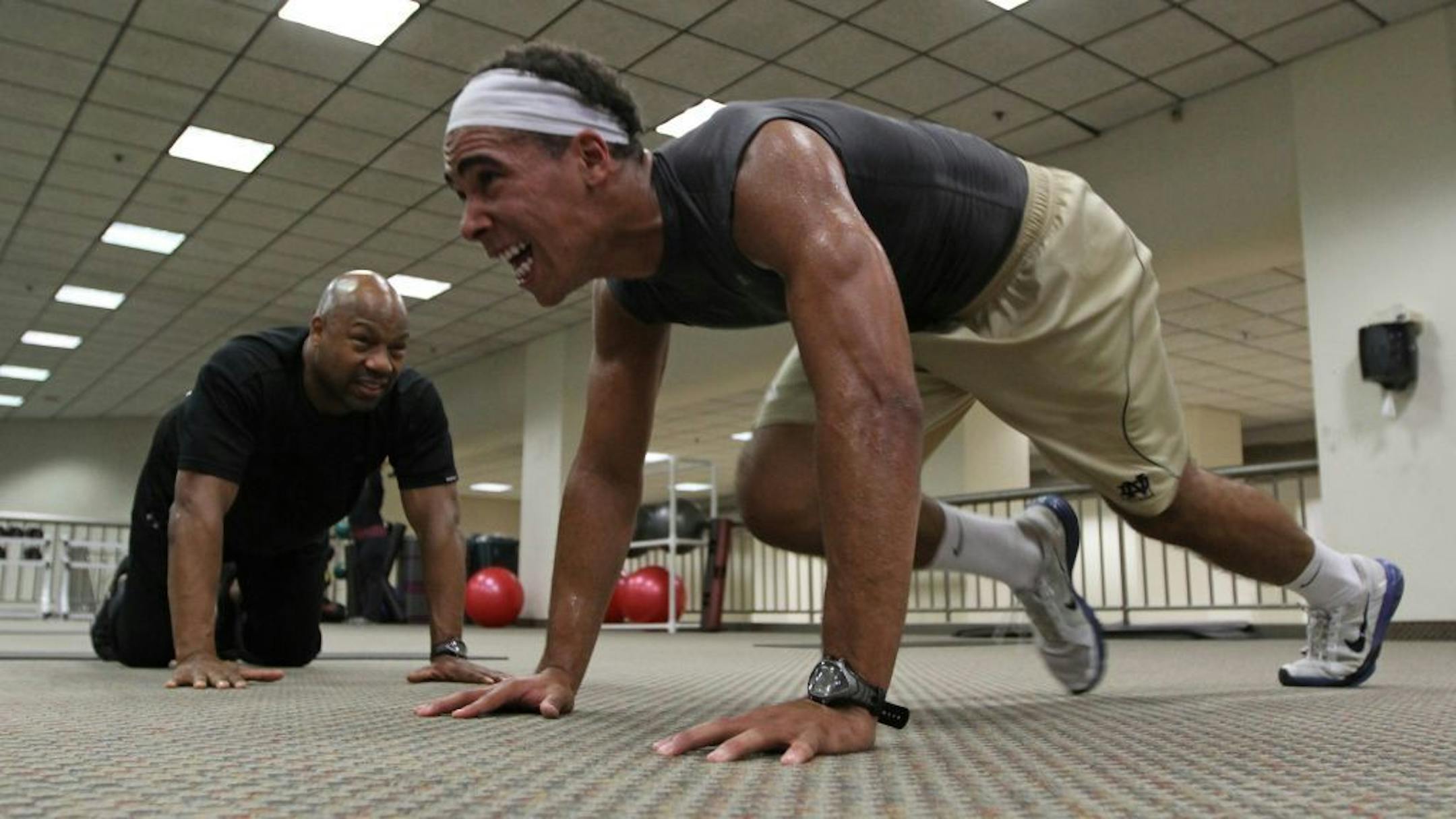 Trainer Ted Johnson watched as James Onwualu worked out in Minneapolis last summer.