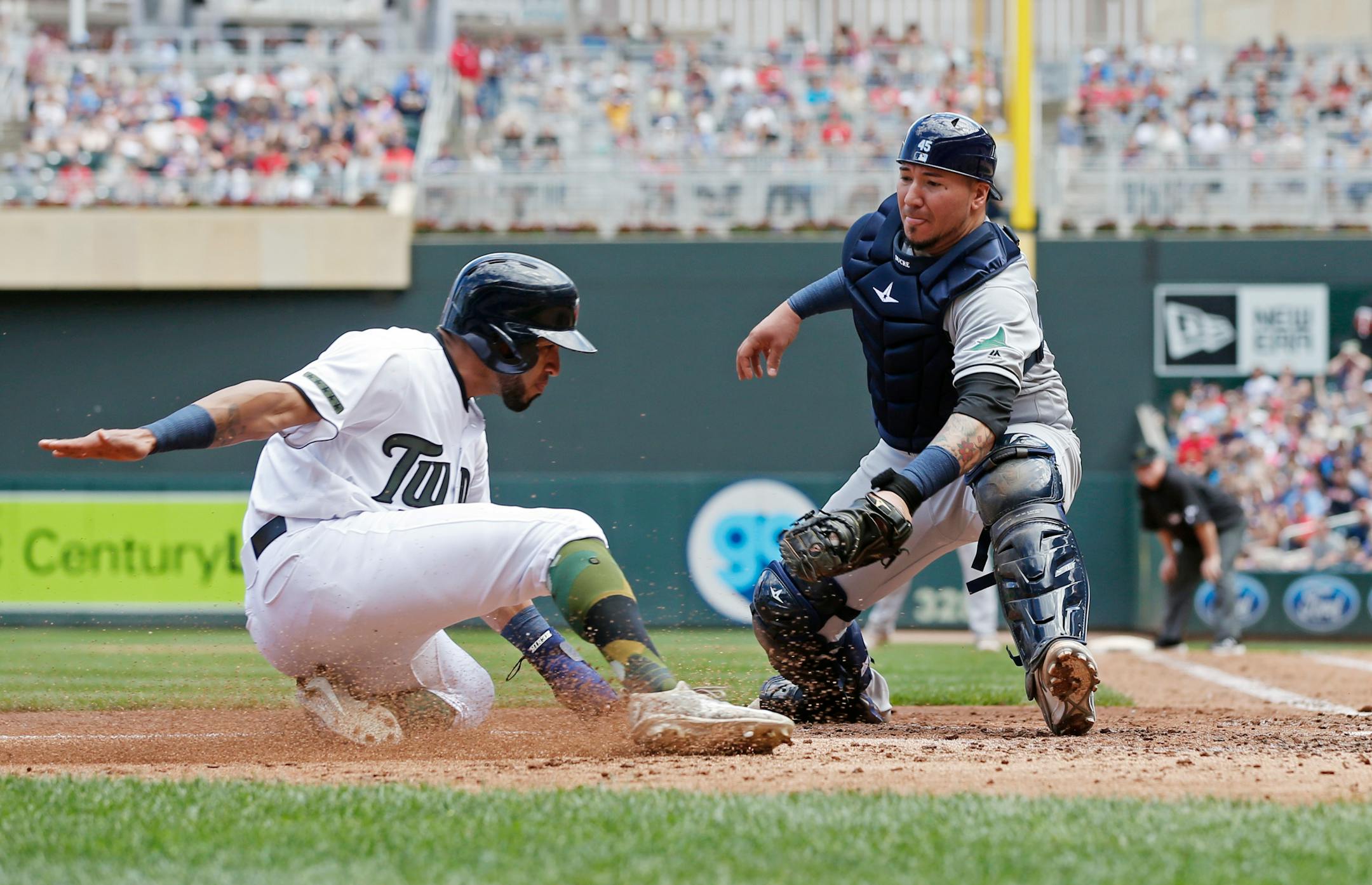 Minnesota Twins' Eddie Rosario,right, tries to score past Tampa Bay Rays catcher Jesus Sucre in the fourth inning of a baseball game Sunday, May 28, 2017 in Minneapolis. (AP Photo/Jim Mone)