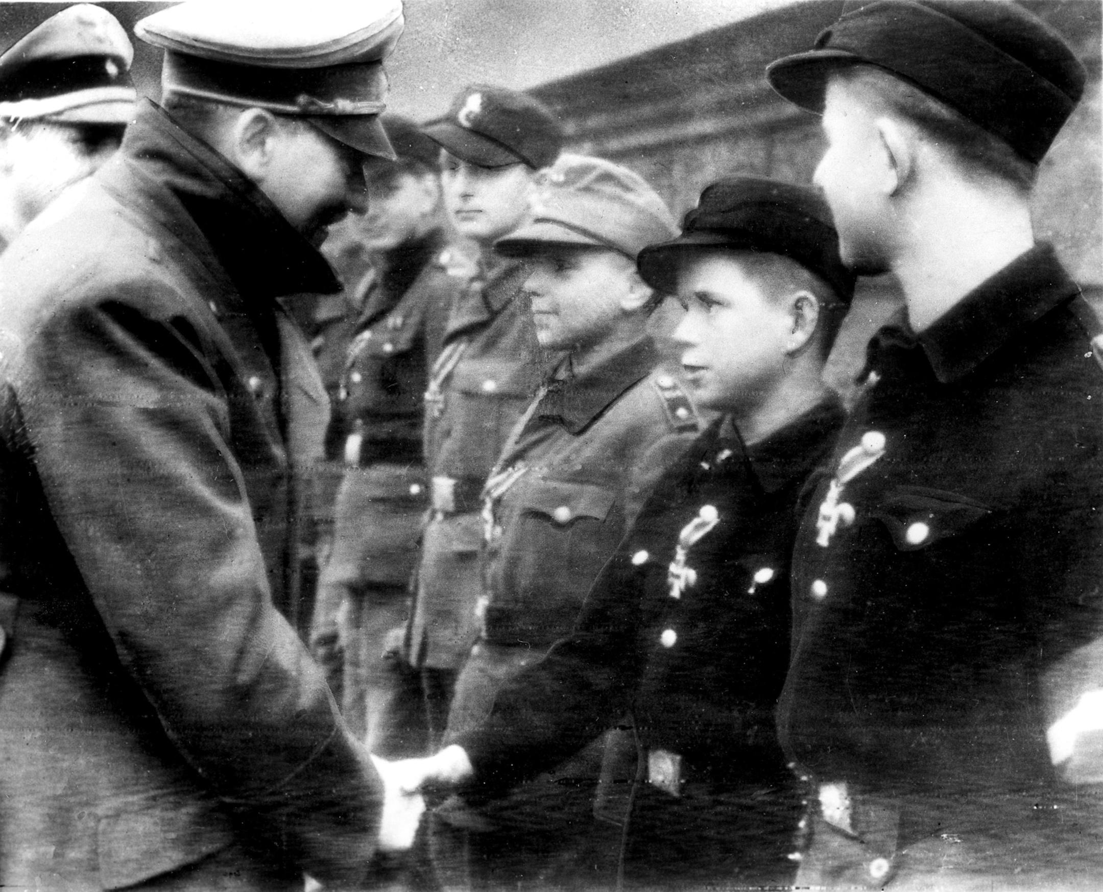Adolf Hitler shook hands with 12-year-old Alfred Czech, a Hitler Youth soldier, after the young veteran of battles in Pomerania and Upper and Lower Silesia was awarded the Iron Cross at Hitler’s headquarters in Germany on March 19, 1945, according to the German caption that accompanied the photo, taken by a Nazi photographer and transmitted to the Associated Press in a secret deal. The image is the last photo AP has of Hitler before he killed himself a few weeks later. 