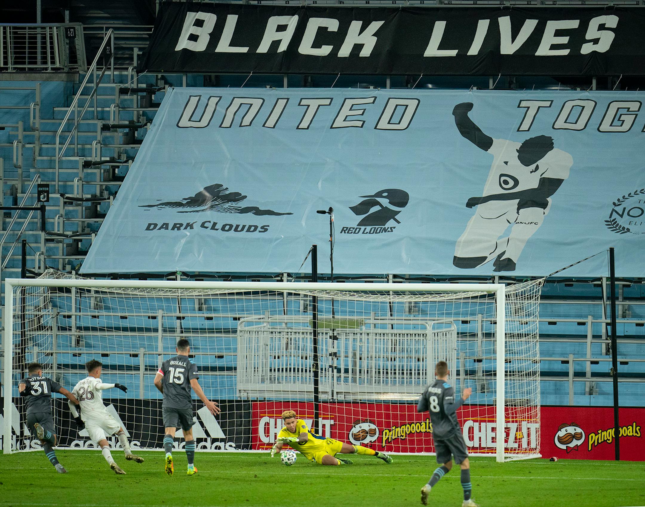 Minnesota United goalkeeper Dayne St. Clair (97) made a second half stop in front of a charging Colorado Rapids midfielder Cole Bassett (26).