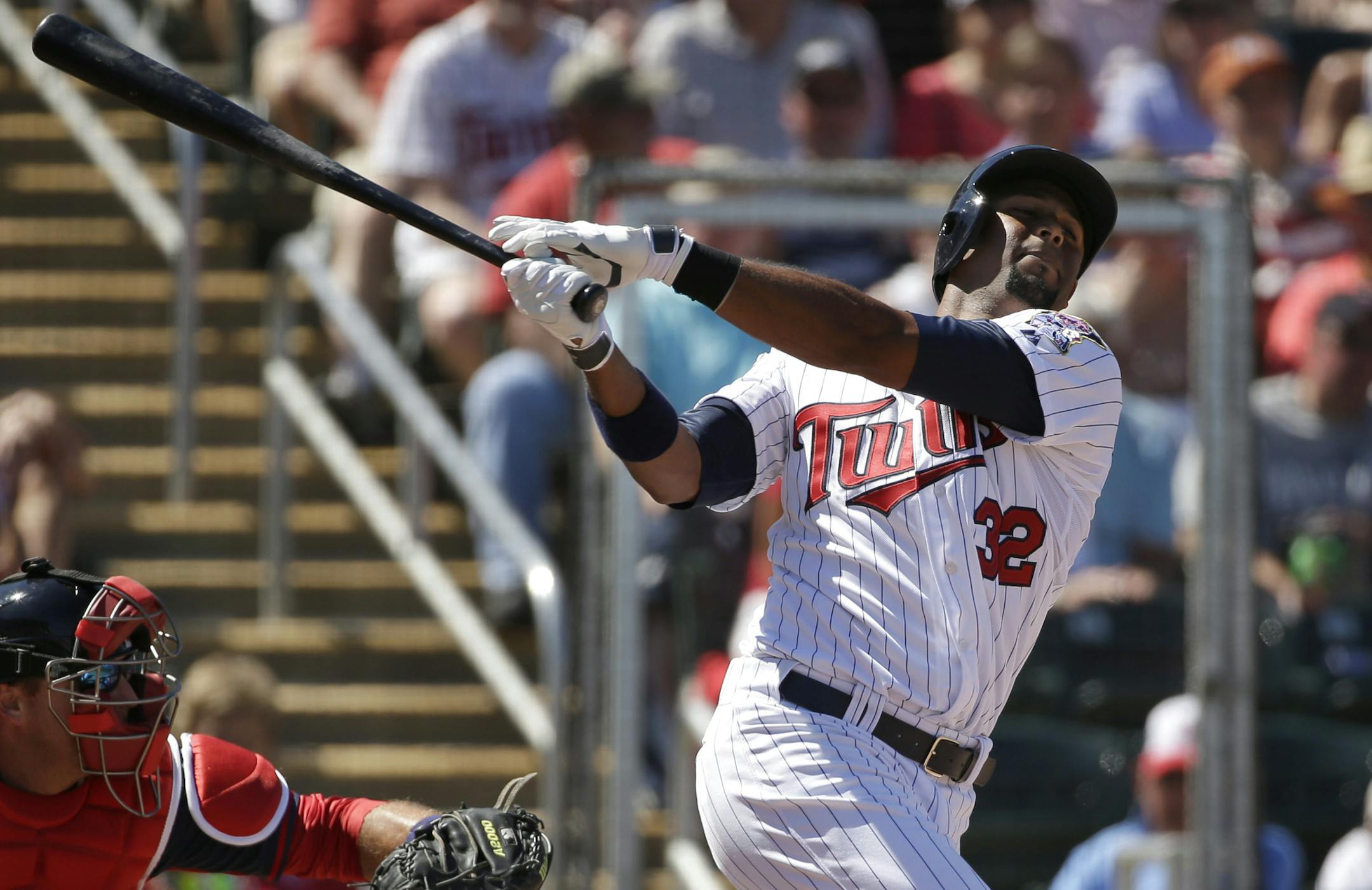 Minnesota Twins' Aaron Hicks follows through on a swing as Boston Red Sox catcher A.J. Pierzynski, left, looks on in the second inning of an exhibition baseball game, Saturday, March 1, 2014, in Fort Myers, Fla. The Twins beat the Red Sox 6-2. (AP Photo/Steven Senne) ORG XMIT: MIN2014033021025246