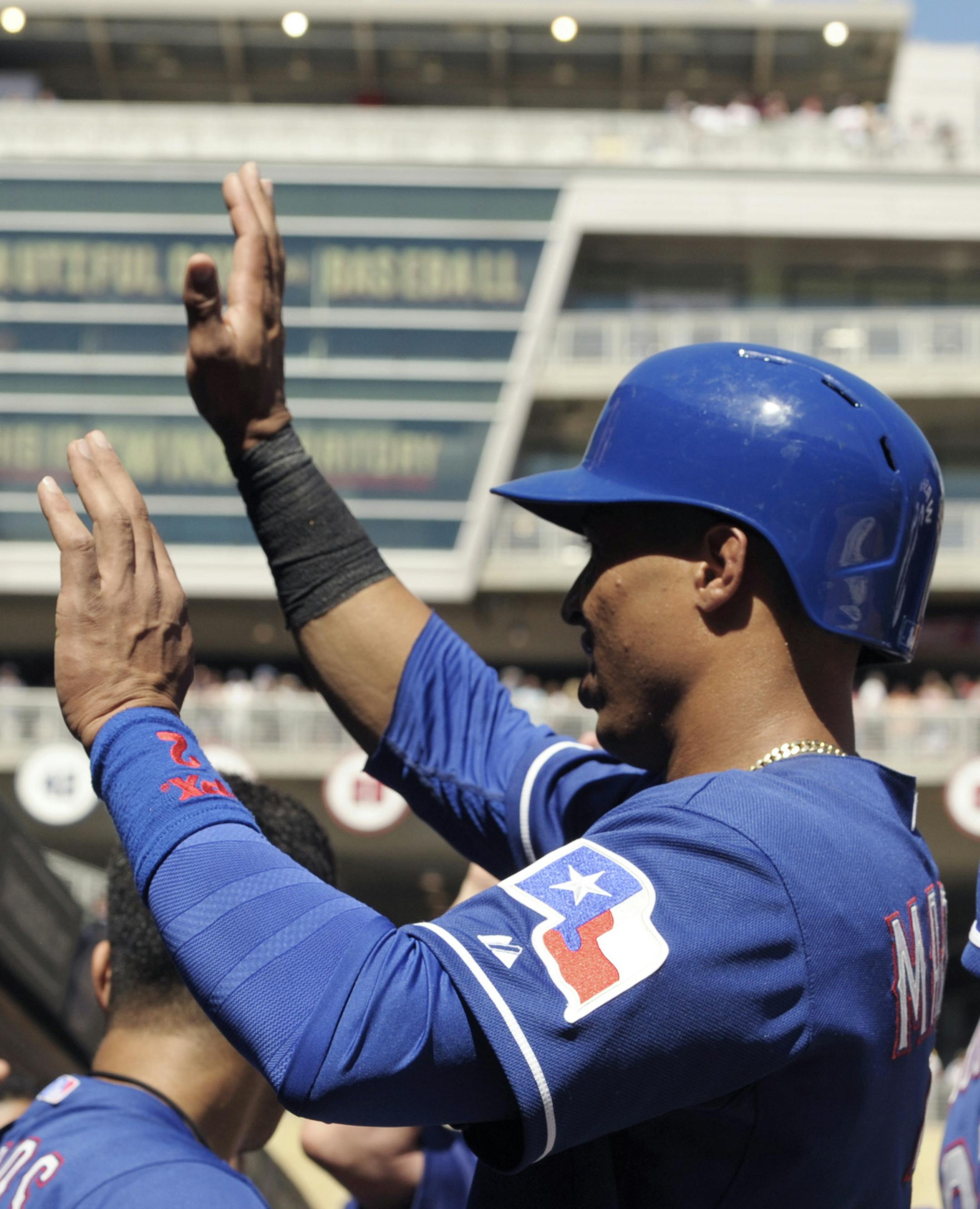 Texas Rangers' Leonys Martin is welcomed in the dugout after he scored the go-ahead run on a sacrifice fly by Rougned Odor in the eighth inning of a baseball game against the Minnesota Twins, Thursday, May 29, 2014, in Minneapolis. The Rangers won 5-4. (AP Photo/Jim Mone)