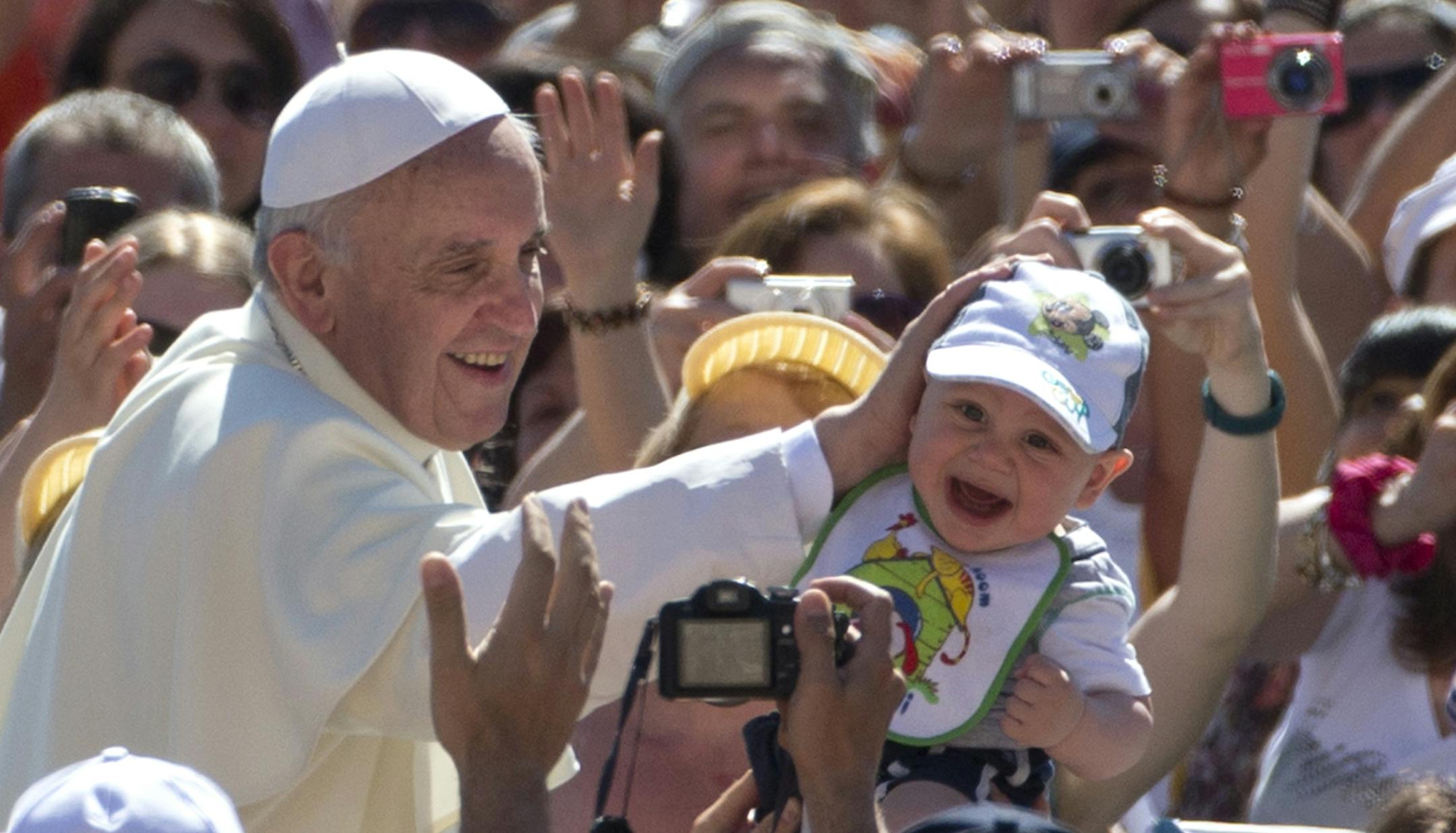 Pope Francis caresses a baby as he arrives in St. Peter's square at the Vatican for his weekly general audience Wednesday, June 12, 2013. (AP Photo/Alessandra Tarantino)