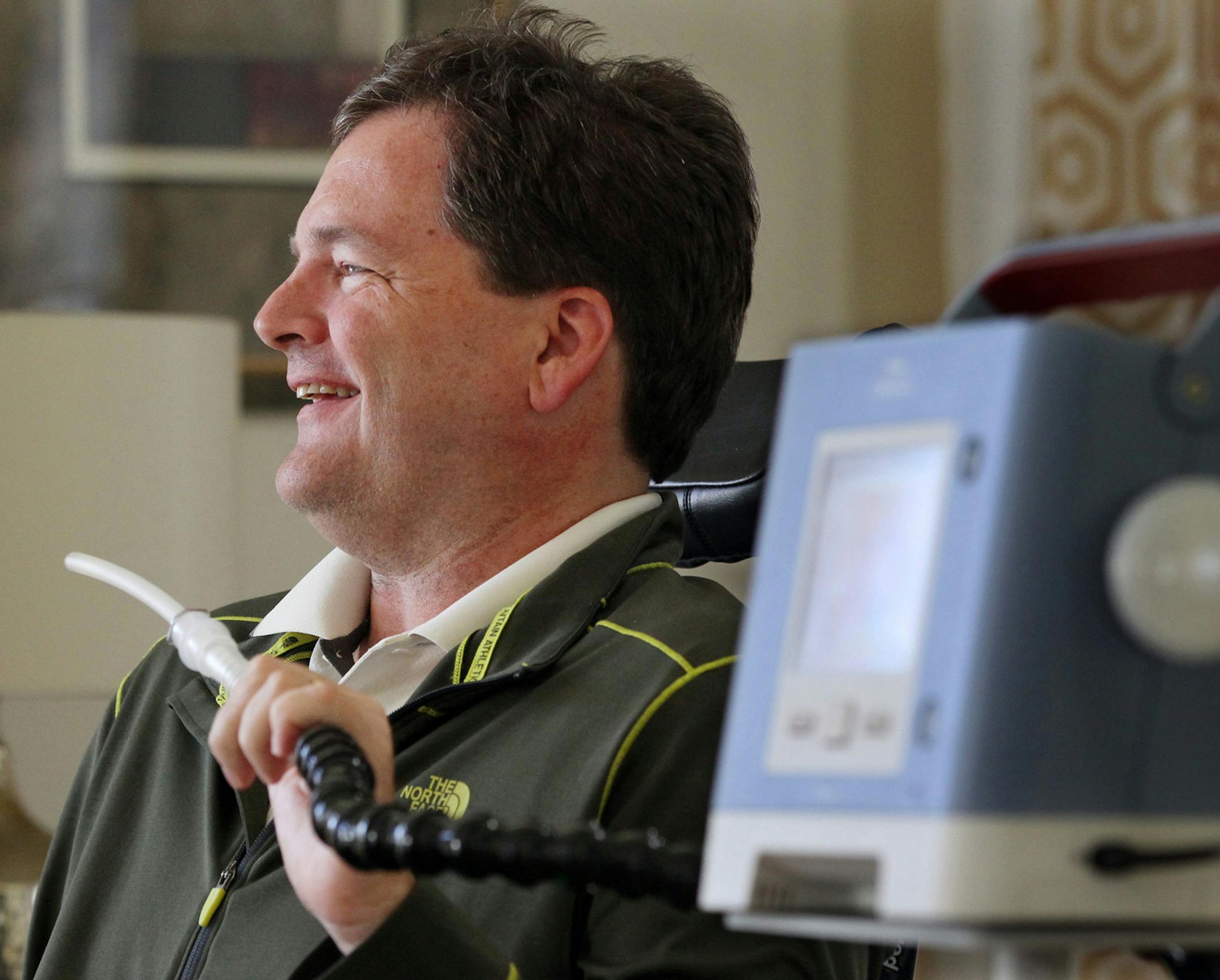 David Stuczynski, who has ALS, holds a tube from a machine that assists his breathing as he talks about recording his voice at the University of Akron on April 28, 2015 at his home in Brecksville, Ohio. (Mike Cardew/Akron Beacon Journal/TNS)