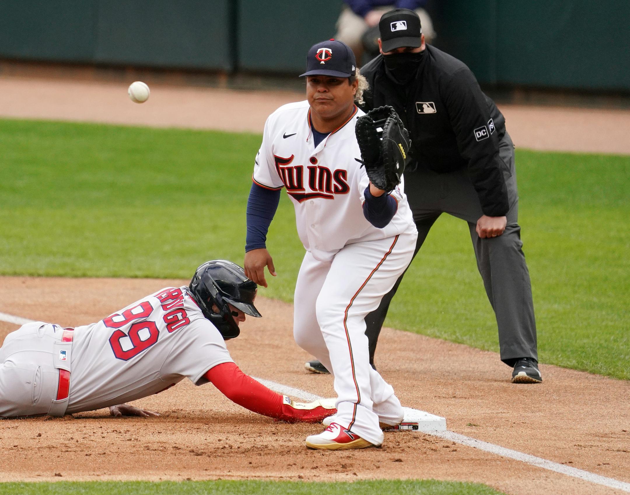 Minnesota Twins first baseman Willians Astudillo (64) caught the ball at first as starting pitcher Kenta Maeda (18) checked Boston Red Sox center fielder Alex Verdugo (99) in the first inning.