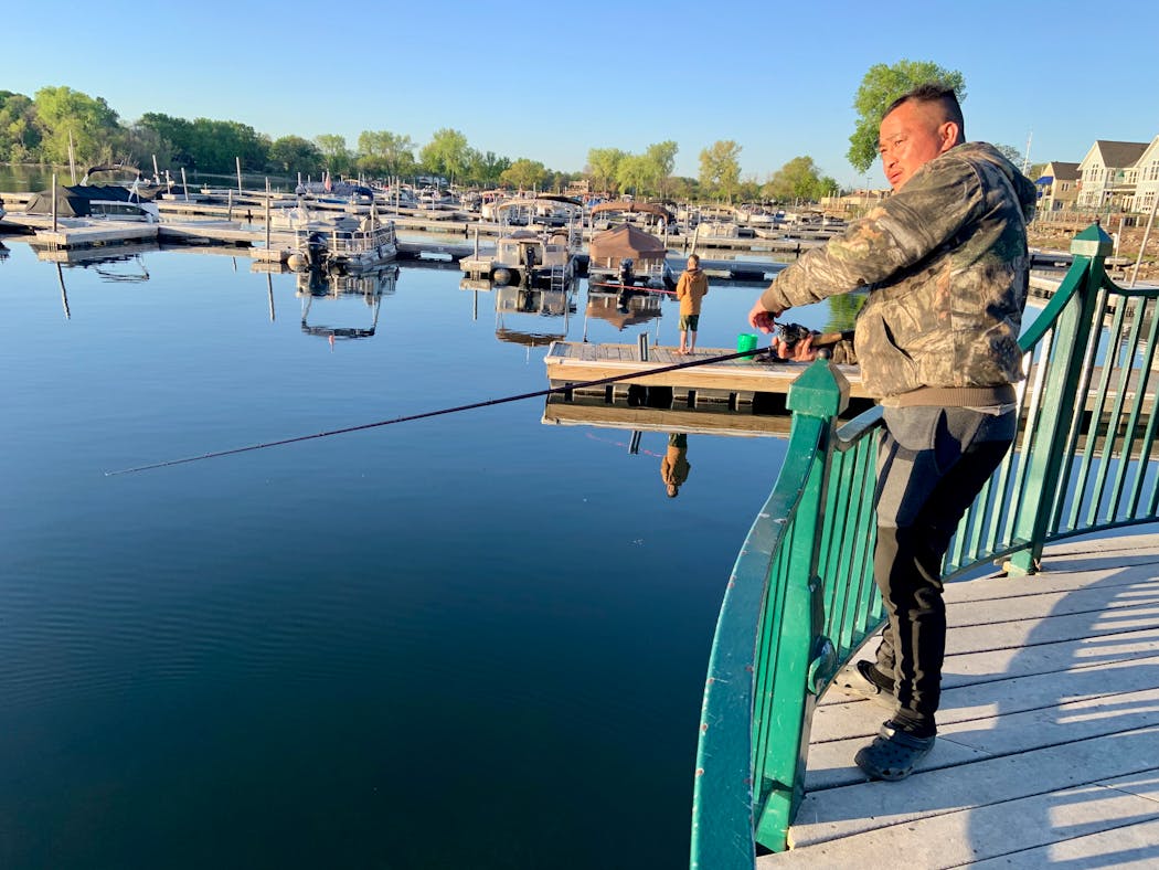 Zoua Vang of St. Paul casts from a pier Saturday morning on the opener near downtown White Bear Lake. Vang caught a nifty 16-inch largemouth bass to start his morning.