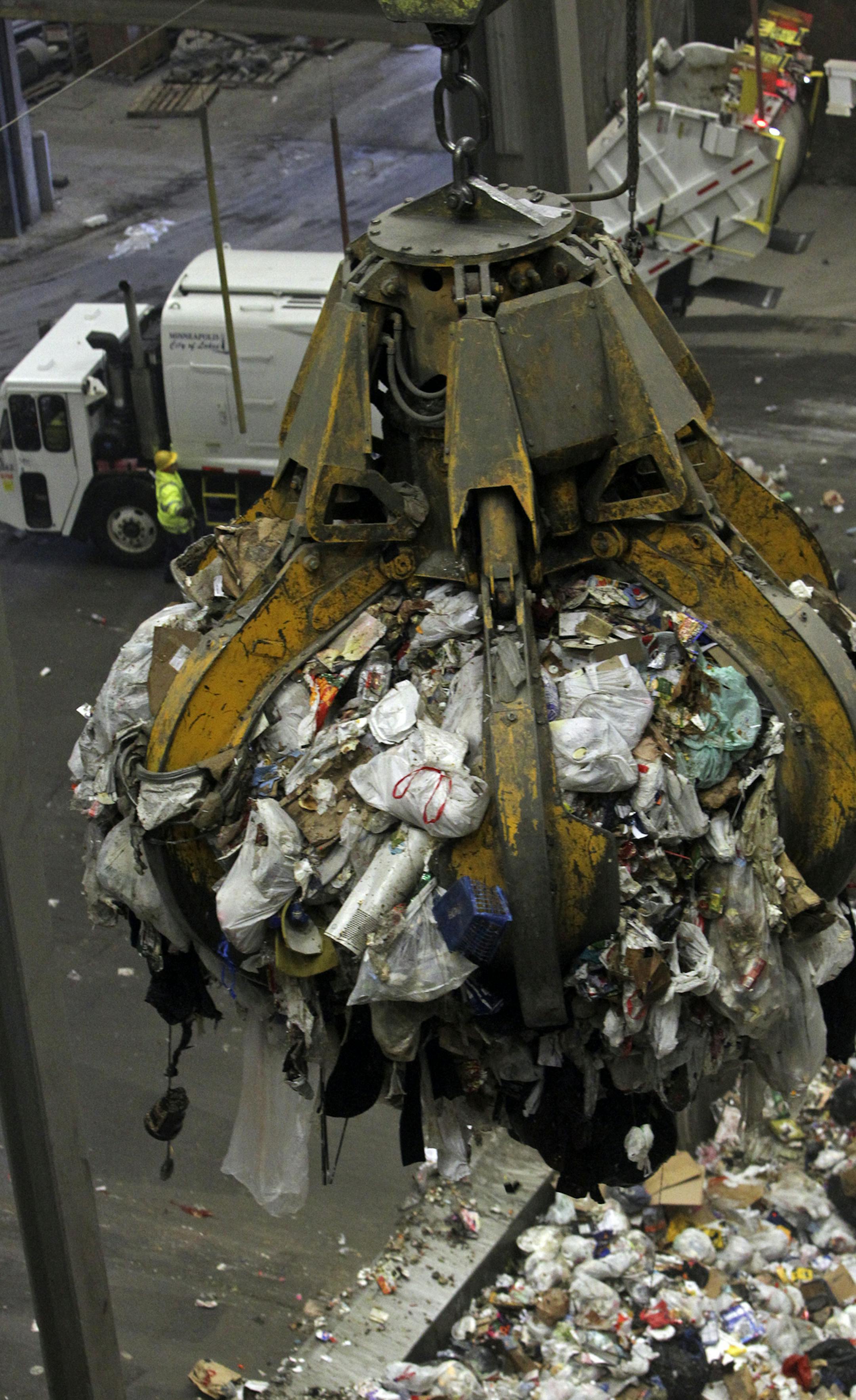A crane grapple lifts a load of garbage for mixing before it is brought into the boiler for waste to energy conversion as a garbage truck dumps its load on the tipping floor Wednesday March 13, 2013, 2013, at the downtown HERC in Minneapolis, MN.] (DAVID JOLES/STARTRIBUNE) djoles@startribune.com A three-way power struggle is heating up over the burning capacity of Hennepin County's downtown facility. The Hennepin Energy Recovery Center (HERC) facility generates enough electricity to power about
