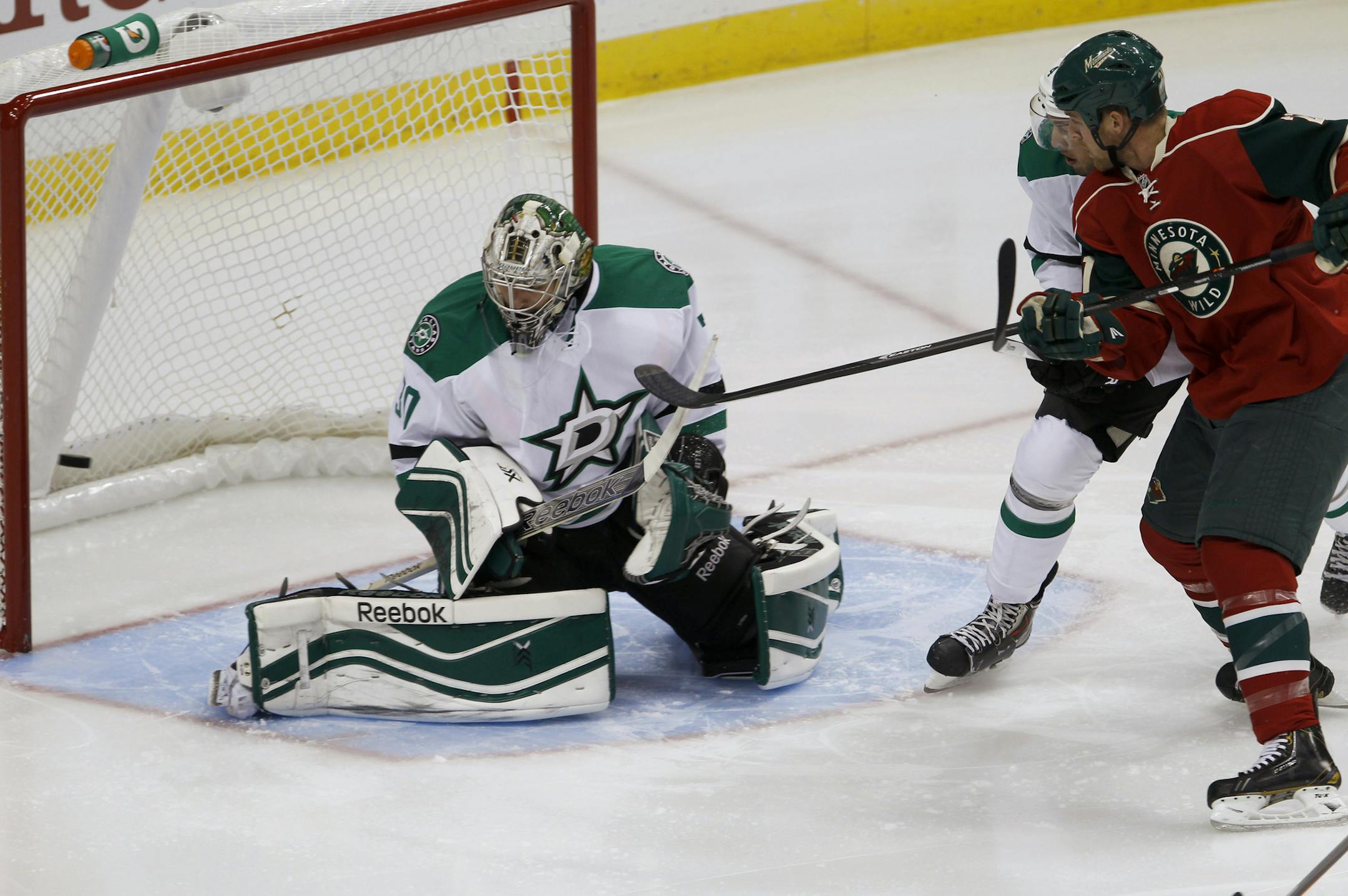 Minnesota Wild center Kyle Brodziak, right, watches as a shot by right wing Justin Fontaine gets past Dallas Stars goalie Dan Ellis for a goal during the first period of an NHL hockey game in St. Paul, Minn., Saturday, Oct. 12, 2013. (AP Photo/Ann Heisenfelt)
