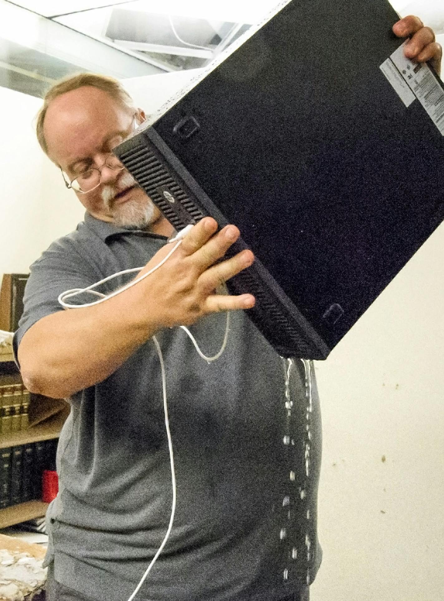 Fiscal Analyst Doug Berg poured water out of his computer on the third floor of the flooded State Office Building at the State Capitol. ] GLEN STUBBE * gstubbe@startribune.com Thursday, July 7, 2016 228799 Water valve broke in the State Office Building, which houses lawmakers and staff. Building was already in need of some work.