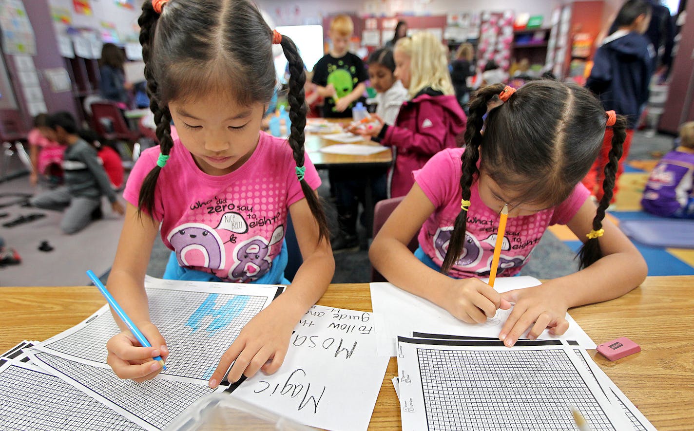 Second-graders Angie, left, and Kayla Luo worked on a project at Greenwood Elementary School in Plymouth. The school starts on the early side, 7:45 a.m.